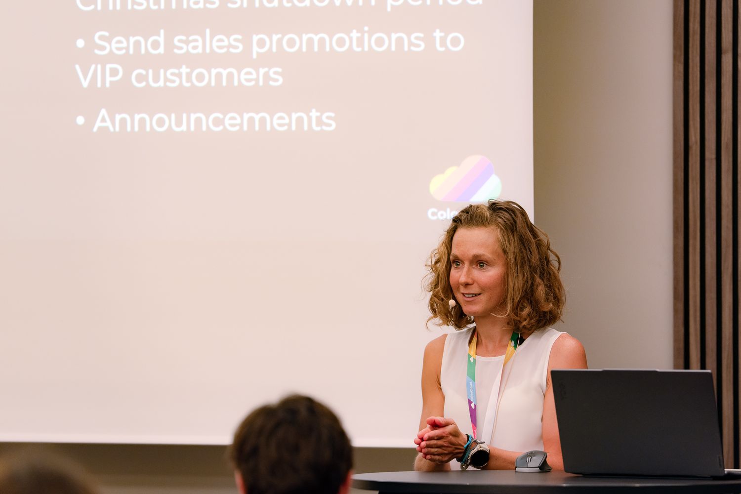 Amey Holden hält mit gefalteten Händen vor den Teilnehmenden an der ColorCloud-Konferenz einen Vortrag