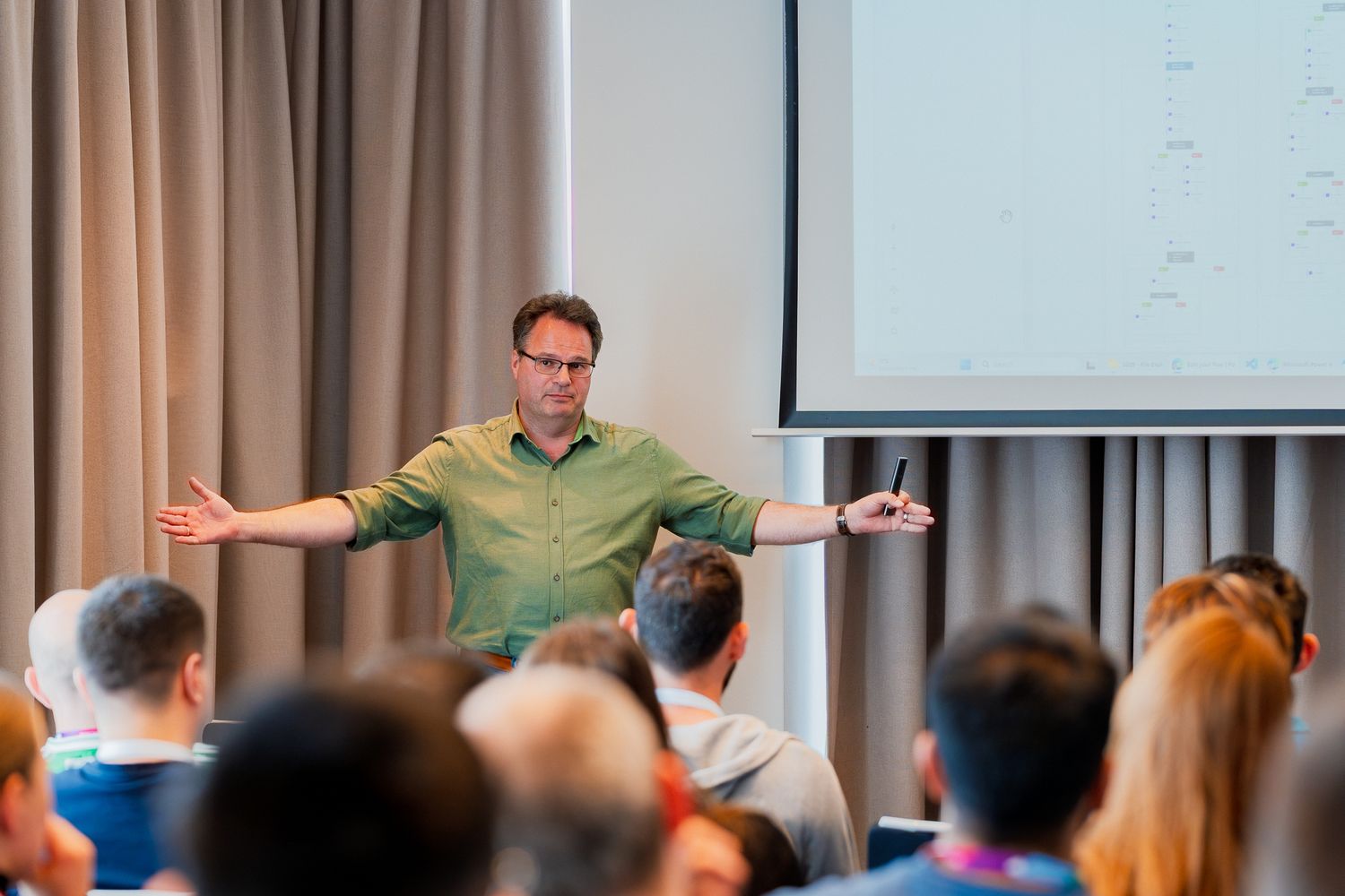 Arend-Jan Kauffmann hält einen Vortrag auf der ColorCloud 2025 und unterstreicht einen Beitrag mit weit ausgestreckten Armen