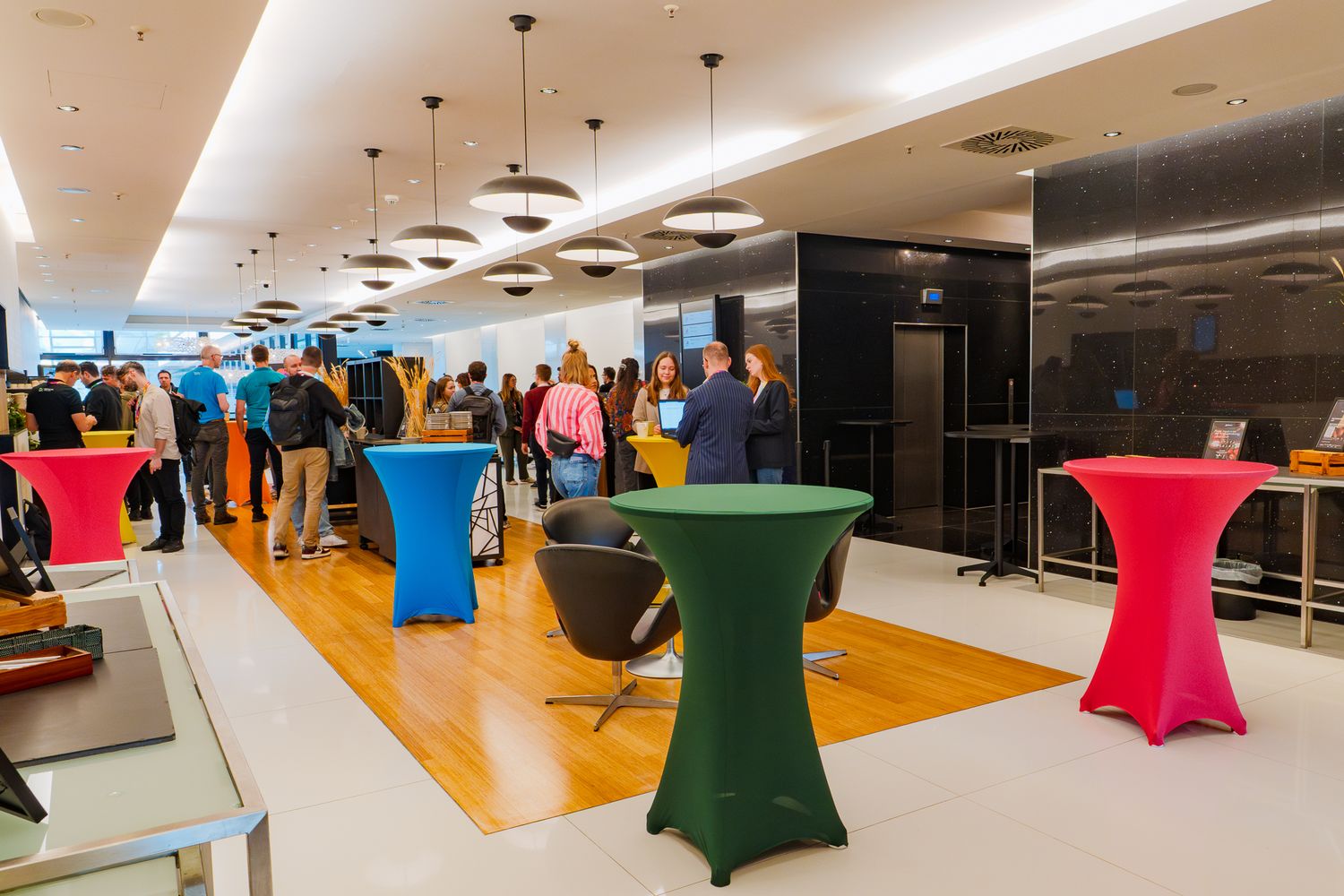 Teilnehmende der ColorCloud-Workshops stehen im Empfangsbereich an Stehtischen und unterhalten sich