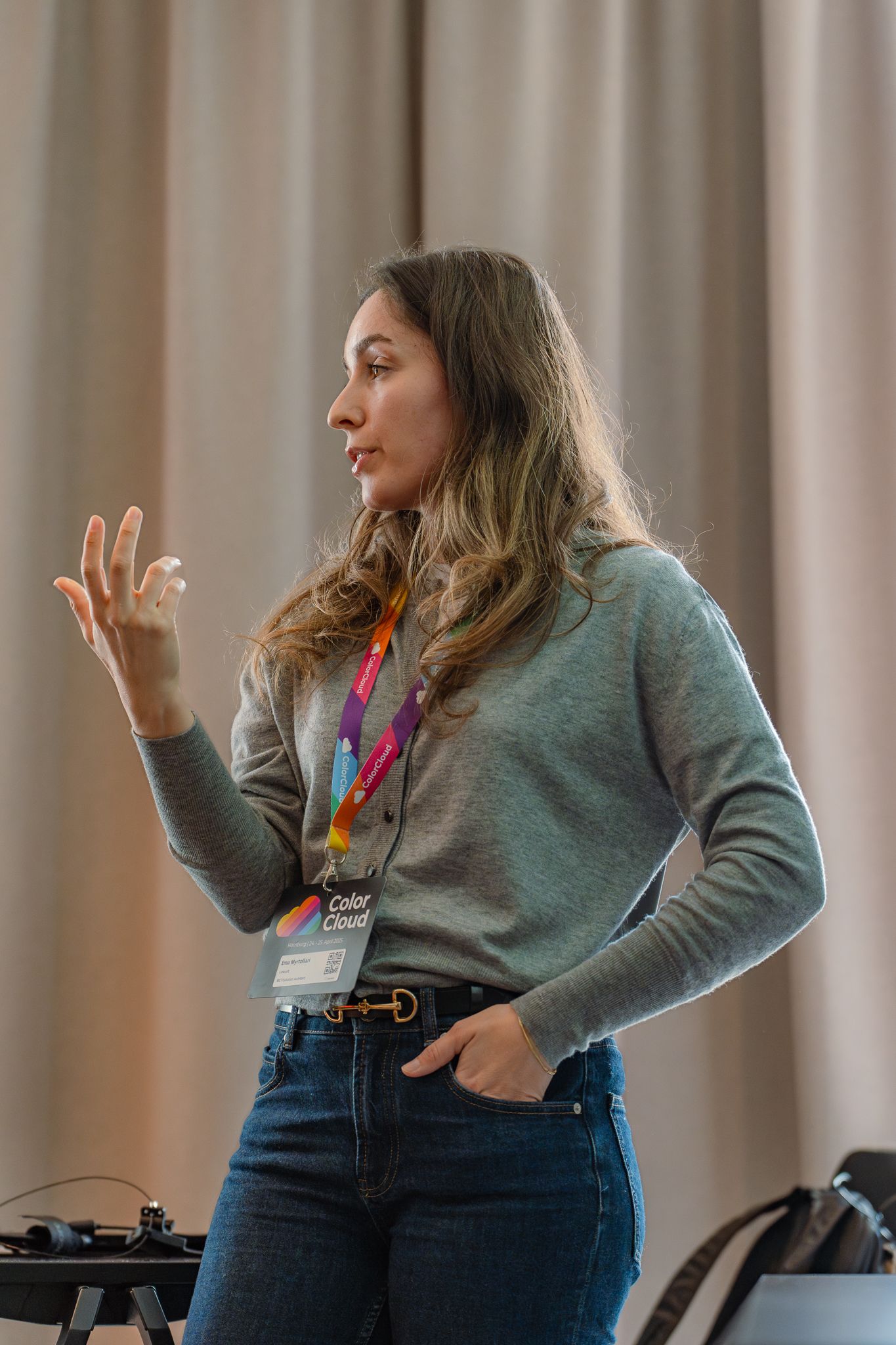 Speakerin Ema Myrtollari hält einen Vortrag auf der ColorCloud-Konferenz 2025 und gestikuliert mit einer Hand