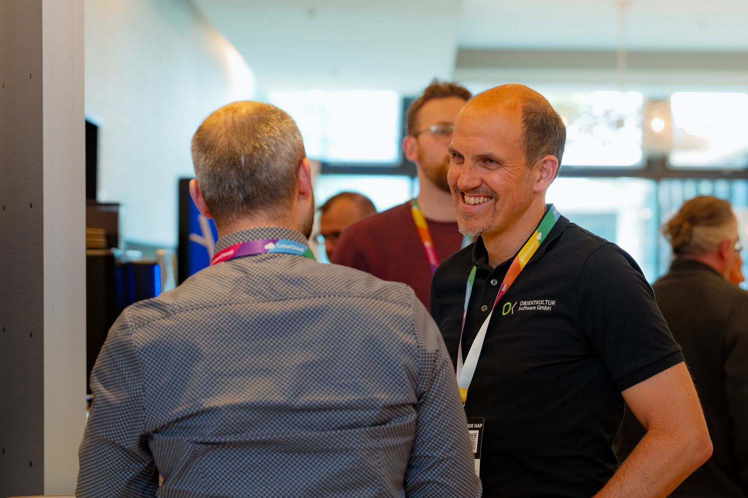 Zwei Männer unterhalten sich im Foyer der ColorCloud-Konferenz während der Pause