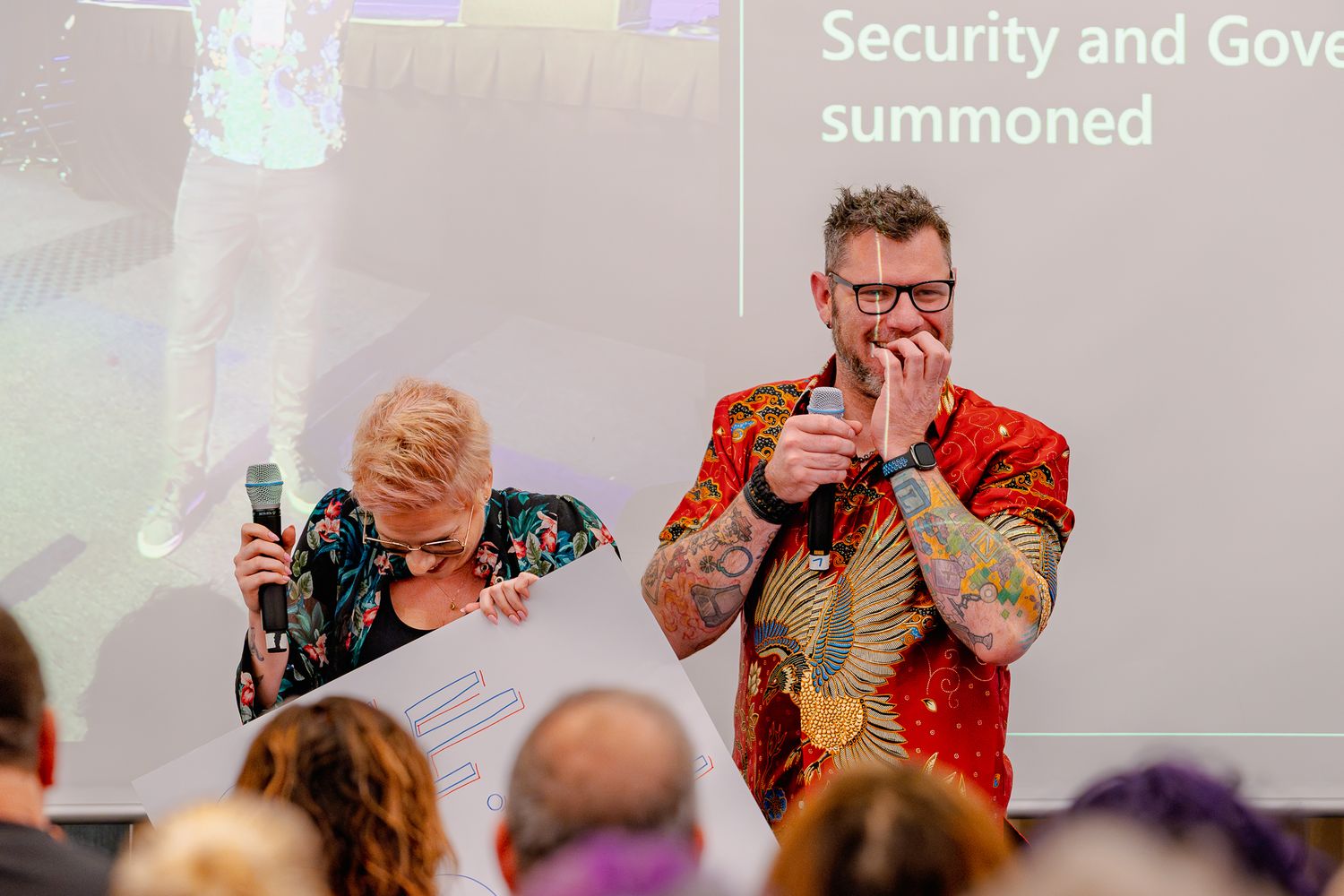 Chris Huntingford hält sich während der Eröffnungsrede der ColorCloud den Mund, während, Sara Lagerquist steht mit Mikrofon neben ihm