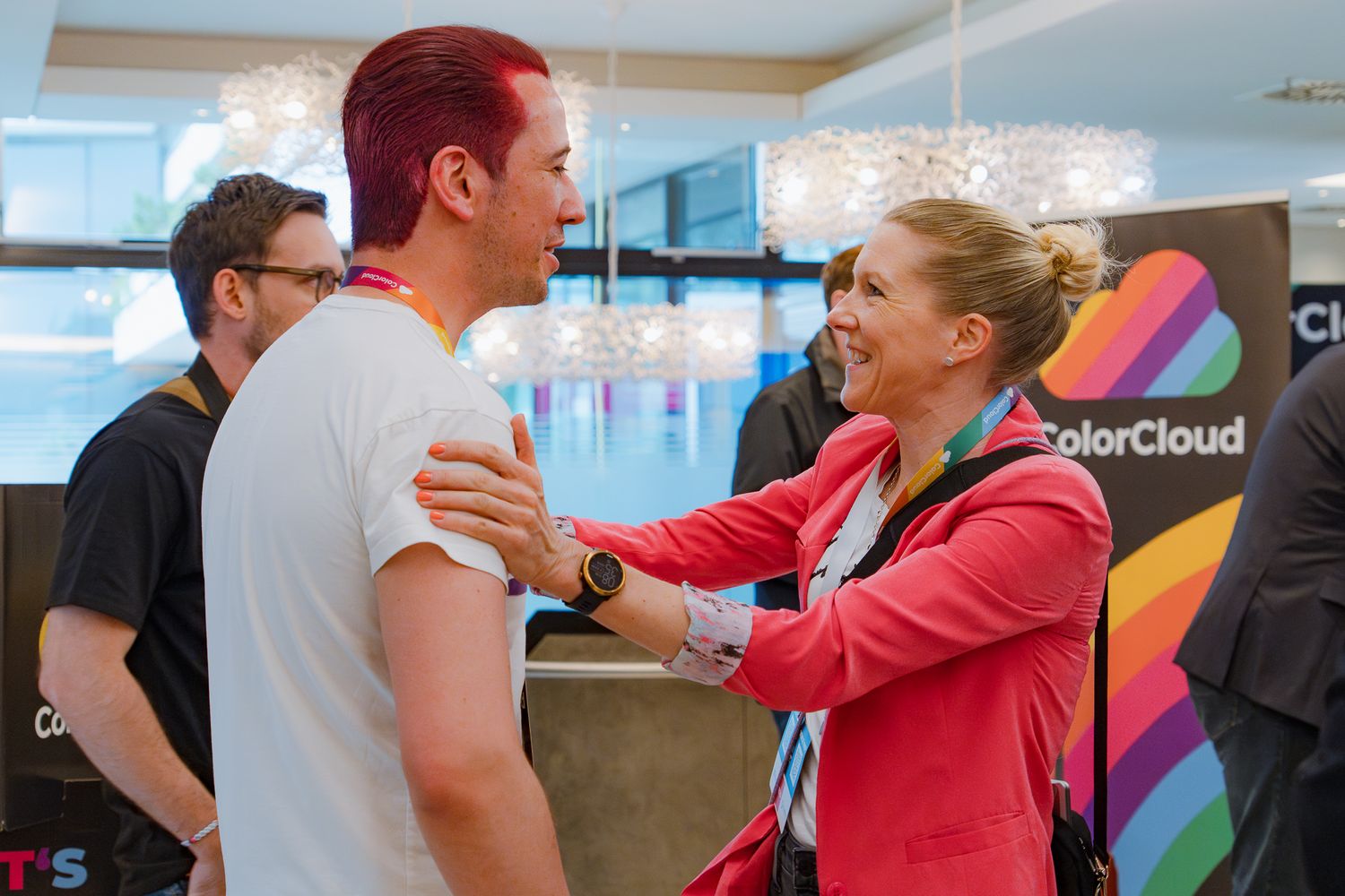 Zwei Teilnehmende der ColorCloud-Konferenz begrüßen sich während der Registrierung