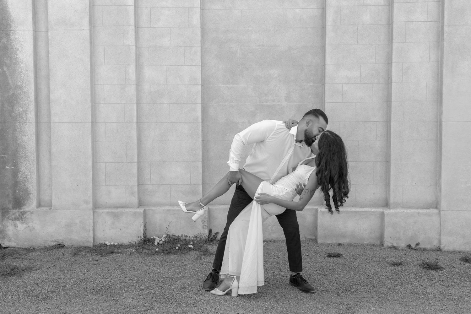 A man dipping a woman while they share a kiss.