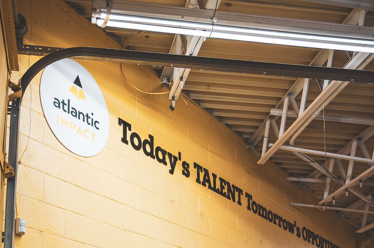 Atlantic sign reading Today's Talent Tomorrow's Opportunity on yellow warehouse wall.