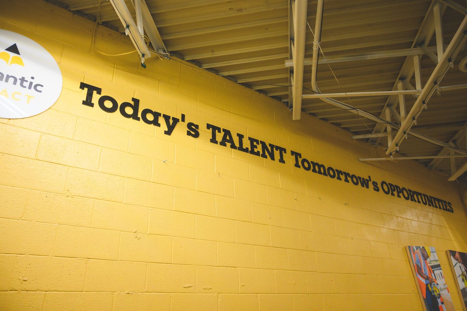 Atlantic Impact: Motivational text reading 'Today's Talent Tomorrow's Opportunity' on yellow painted wall under industrial ceiling.