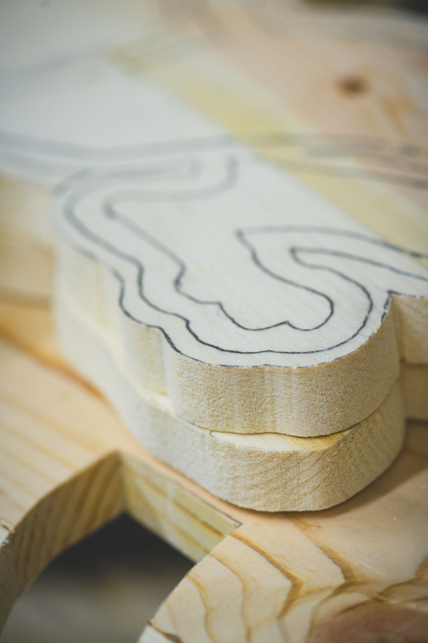 Close-up sequence showing progressive cutting of a curved pattern in light-colored wood with fine detailing.