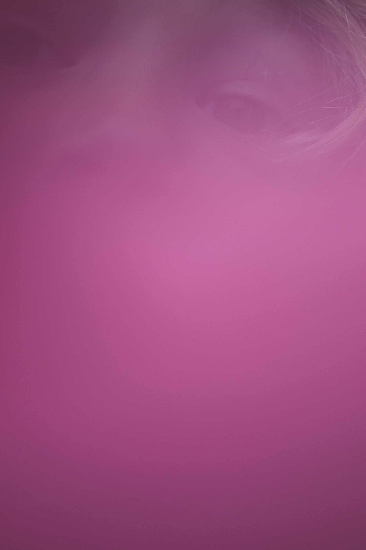 Abstract pink and magenta gradient background with soft swirling smoke or fog creating a dreamy, ethereal atmosphere.