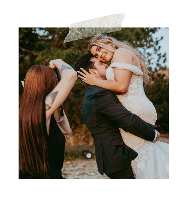 A joyful couple in wedding attire embrace and laugh together during an outdoor photo session.