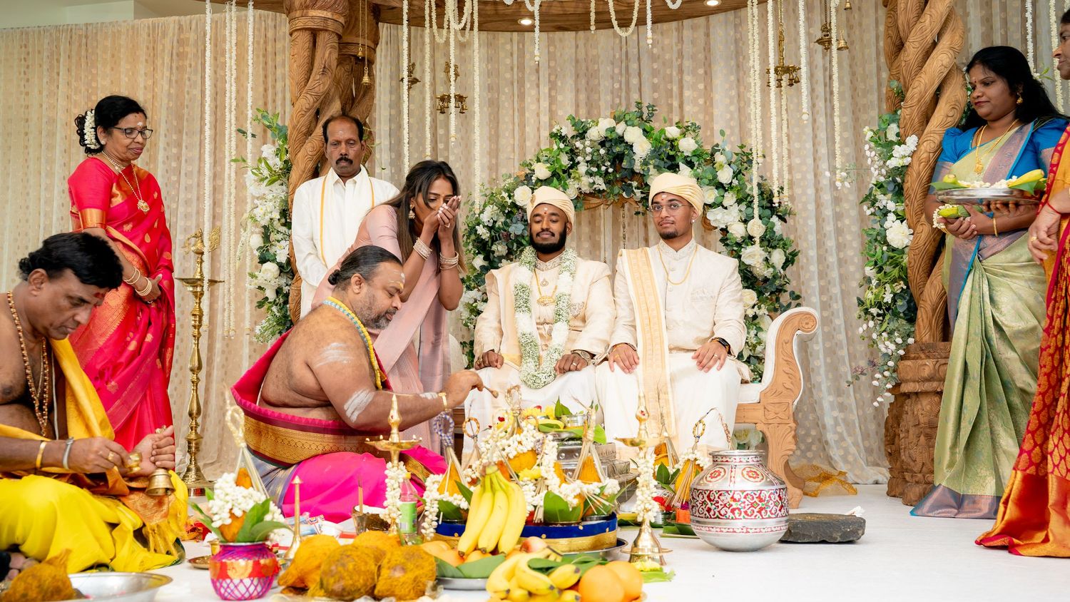 Hindu priests perform sacred rituals as guests gather around the mandap during a South Indian wedding.