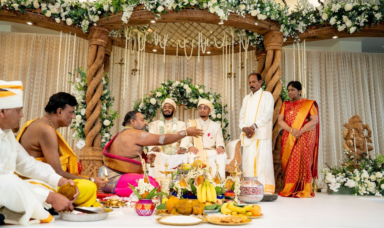 Hindu priest offers sacred water to the groom during a traditional South Indian wedding ritual.