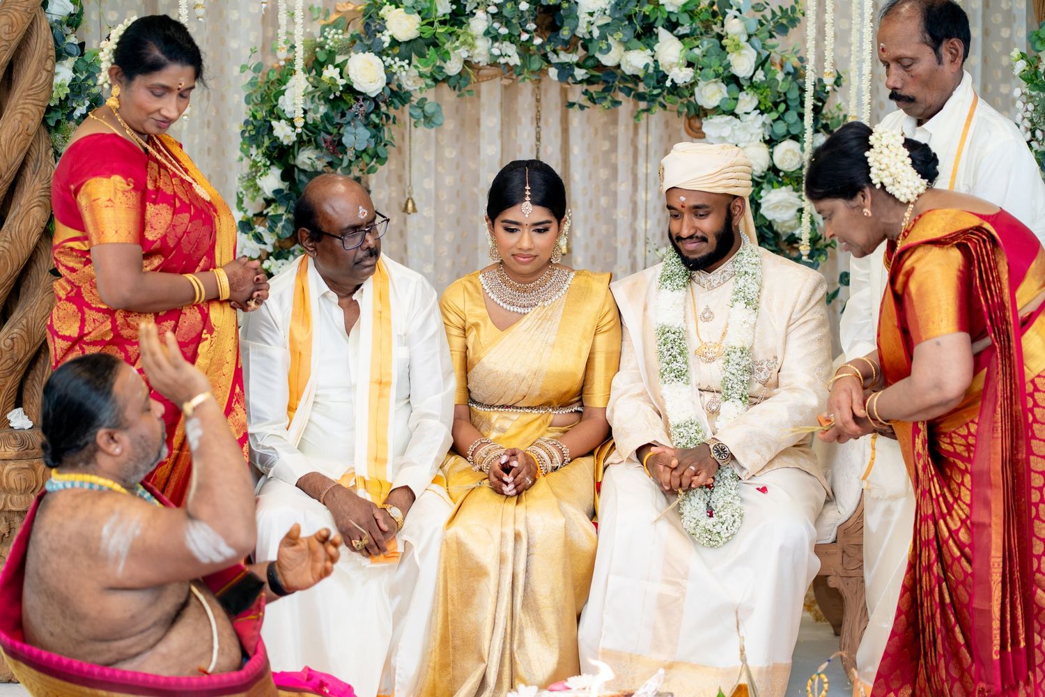 Traditional South Indian wedding with family gathered around bride and groom during sacred ceremony rituals.