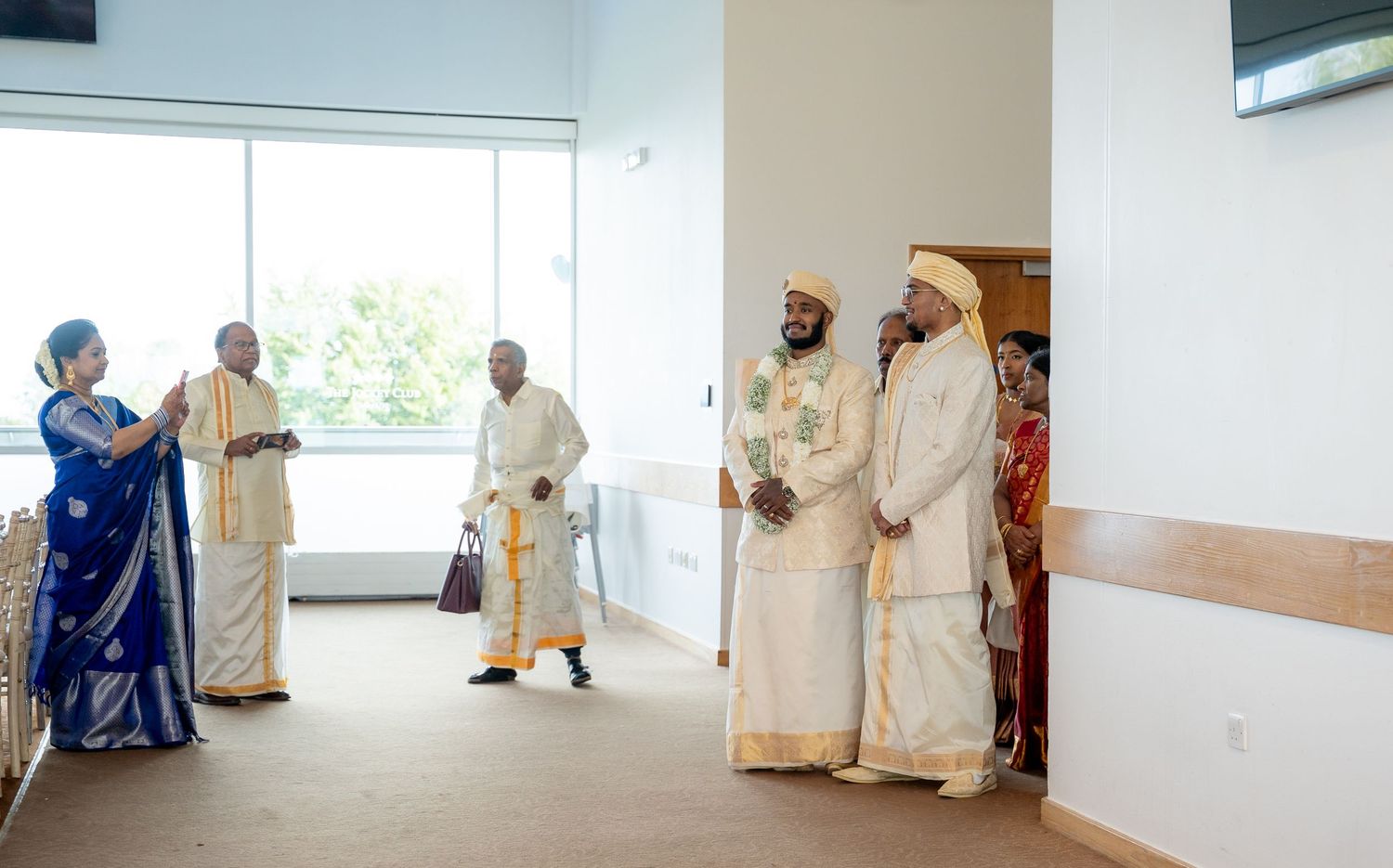 People in traditional Ethiopian white ceremonial attire gather in a modern hall during a cultural or religious celebration.
