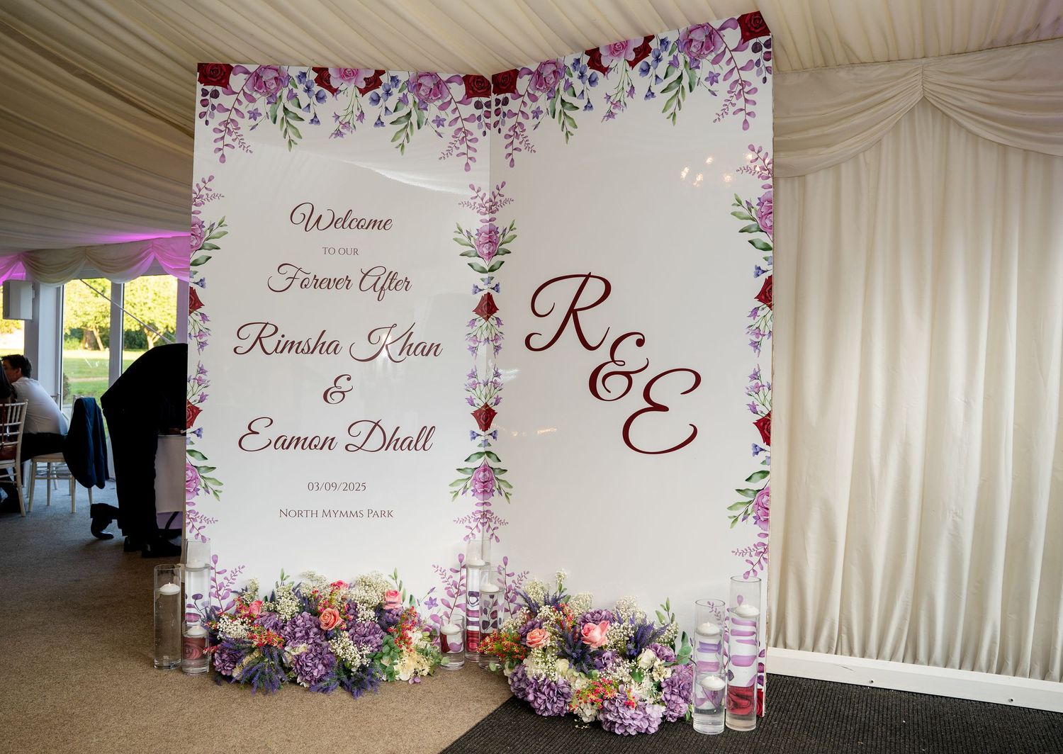 Elegant wedding welcome sign for Rimsha Khan and Eamon Dhall decorated with purple and pink floral arrangements.