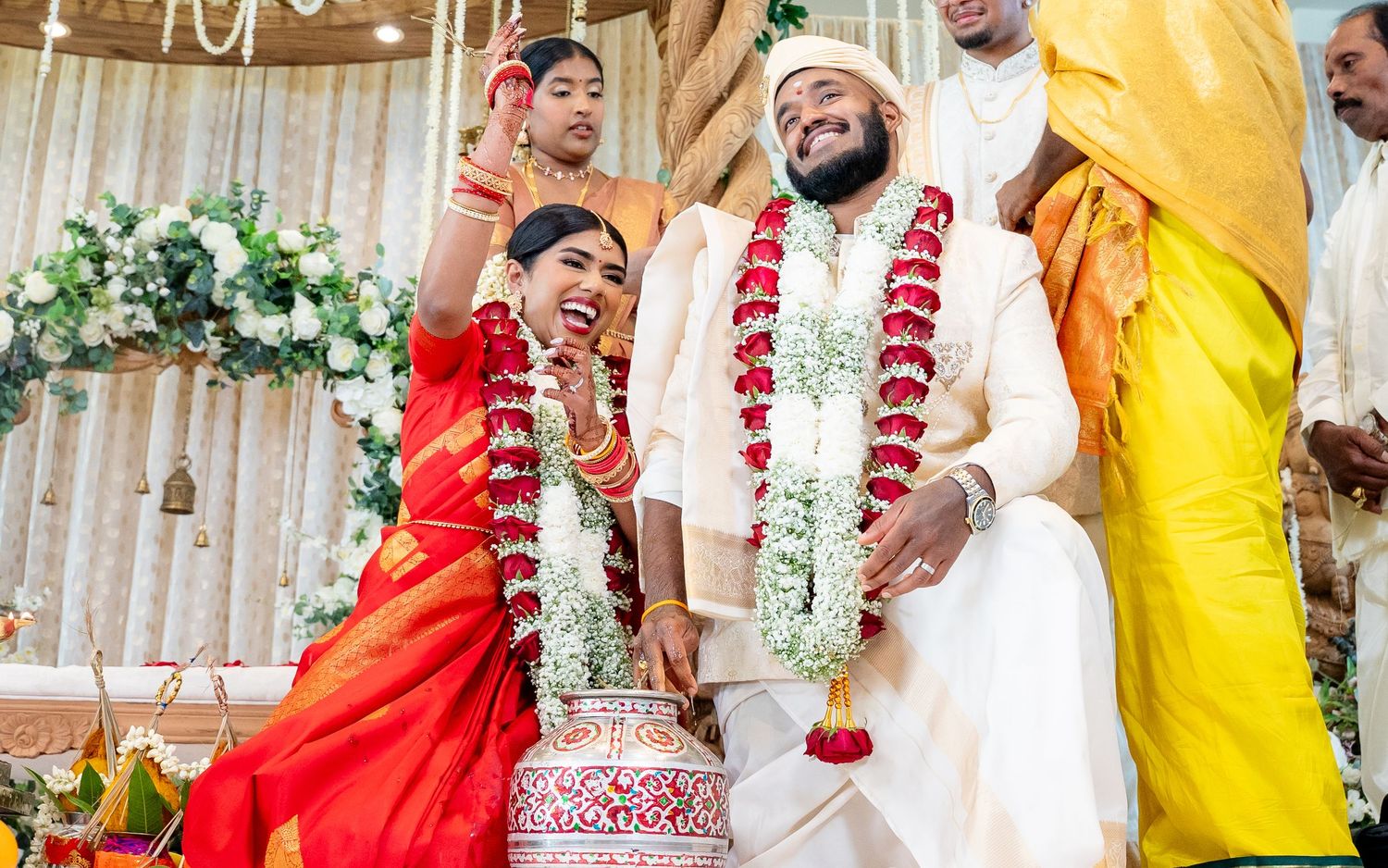 Bride and groom exchange garlands during a traditional Hindu wedding ceremony at a decorated mandap.