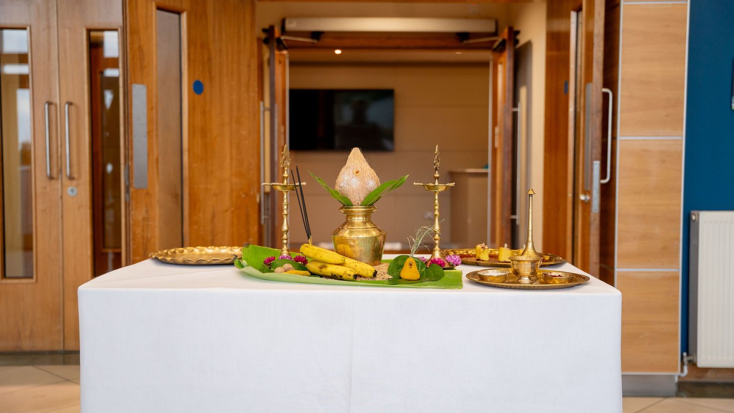 Traditional Kerala wedding table with brass lamps, banana leaf, and ritual offerings.