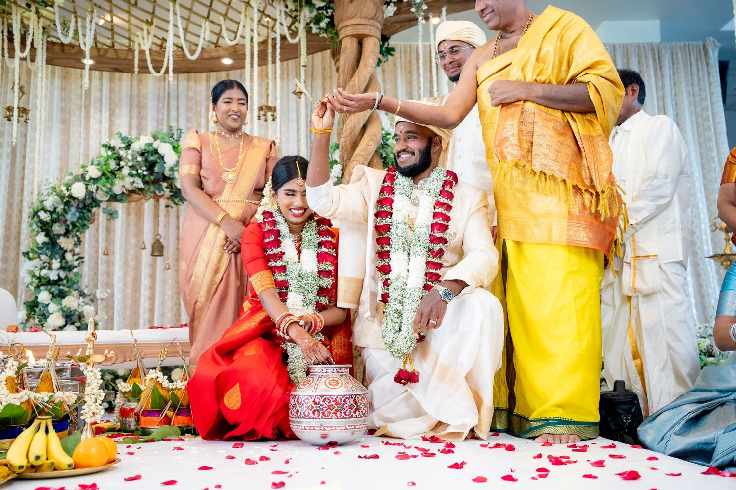 South Indian wedding couple receiving blessings from priest during traditional mandap ceremony.