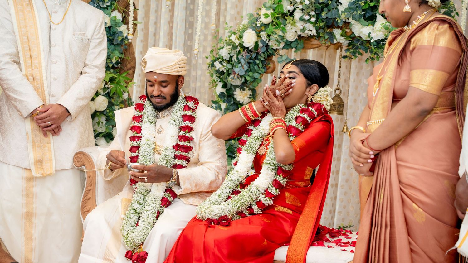 Emotional moment as bride touches grooms face during colorful South Indian Hindu wedding celebration.