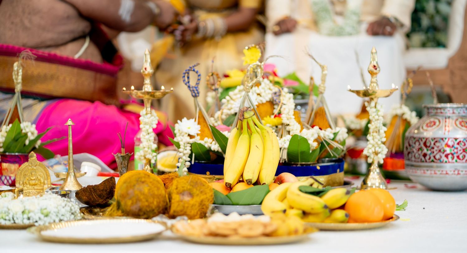 Traditional Hindu wedding ceremony offerings including bananas, fruits, flowers and ritual items on decorated altar.
