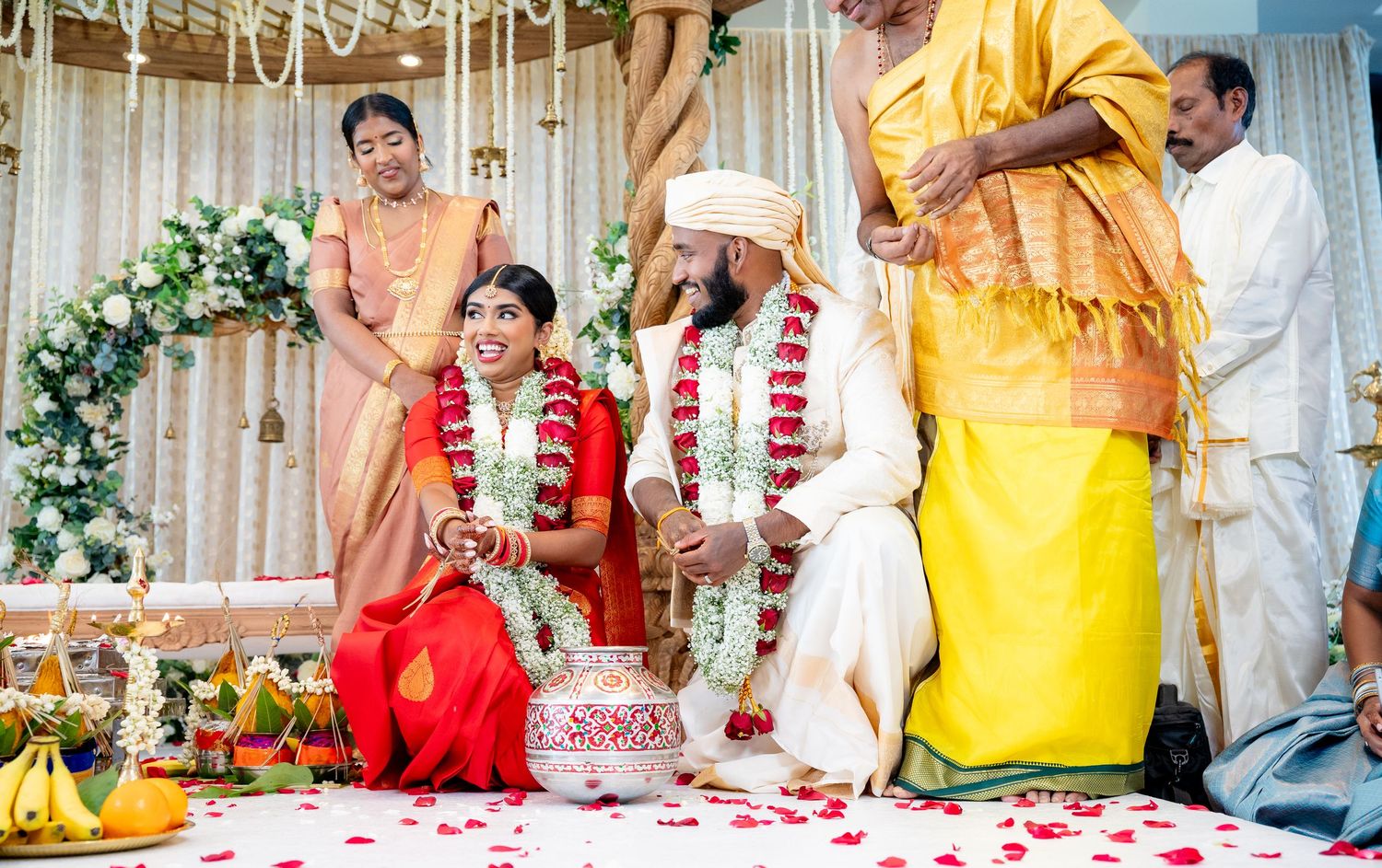 Traditional South Indian wedding ceremony with family and priest at beautifully decorated mandap.