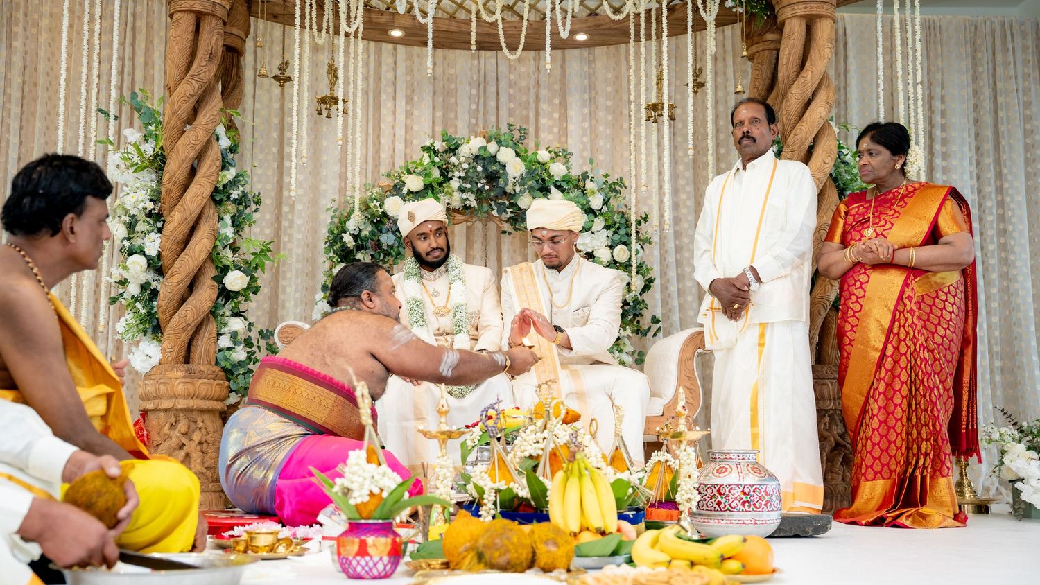 Hindu priest performs sacred rituals for the groom at a traditional South Indian wedding ceremony.
