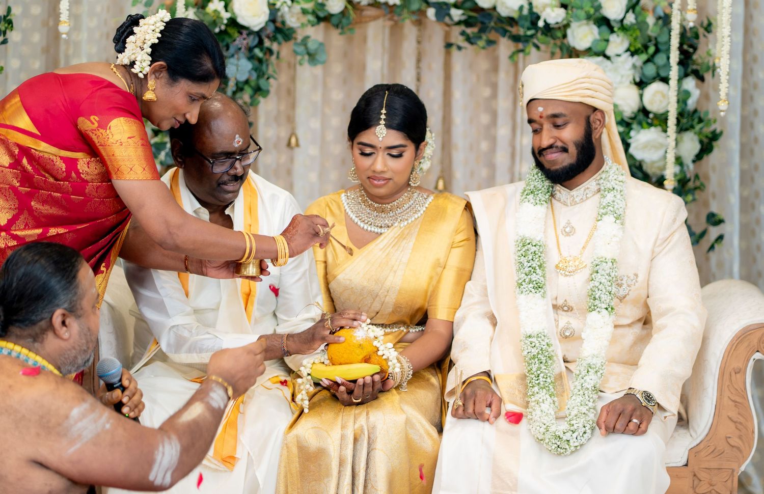 South Indian wedding blessing ceremony with family elder performing rituals for bride and groom at mandap.
