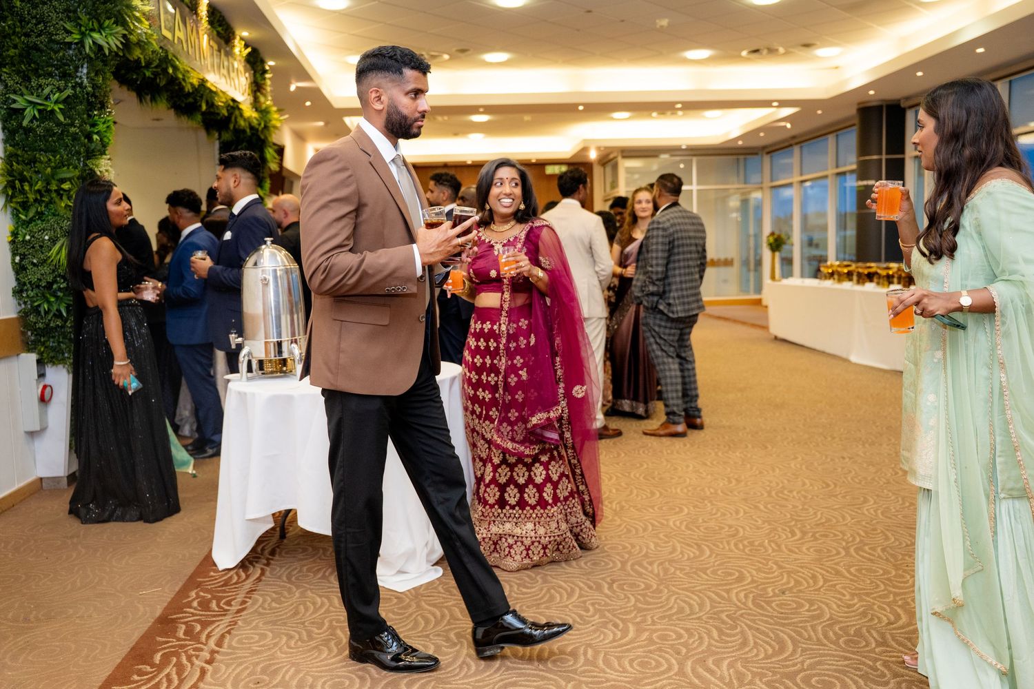 Guests mingling in traditional Indian wedding attire at an elegant reception venue.