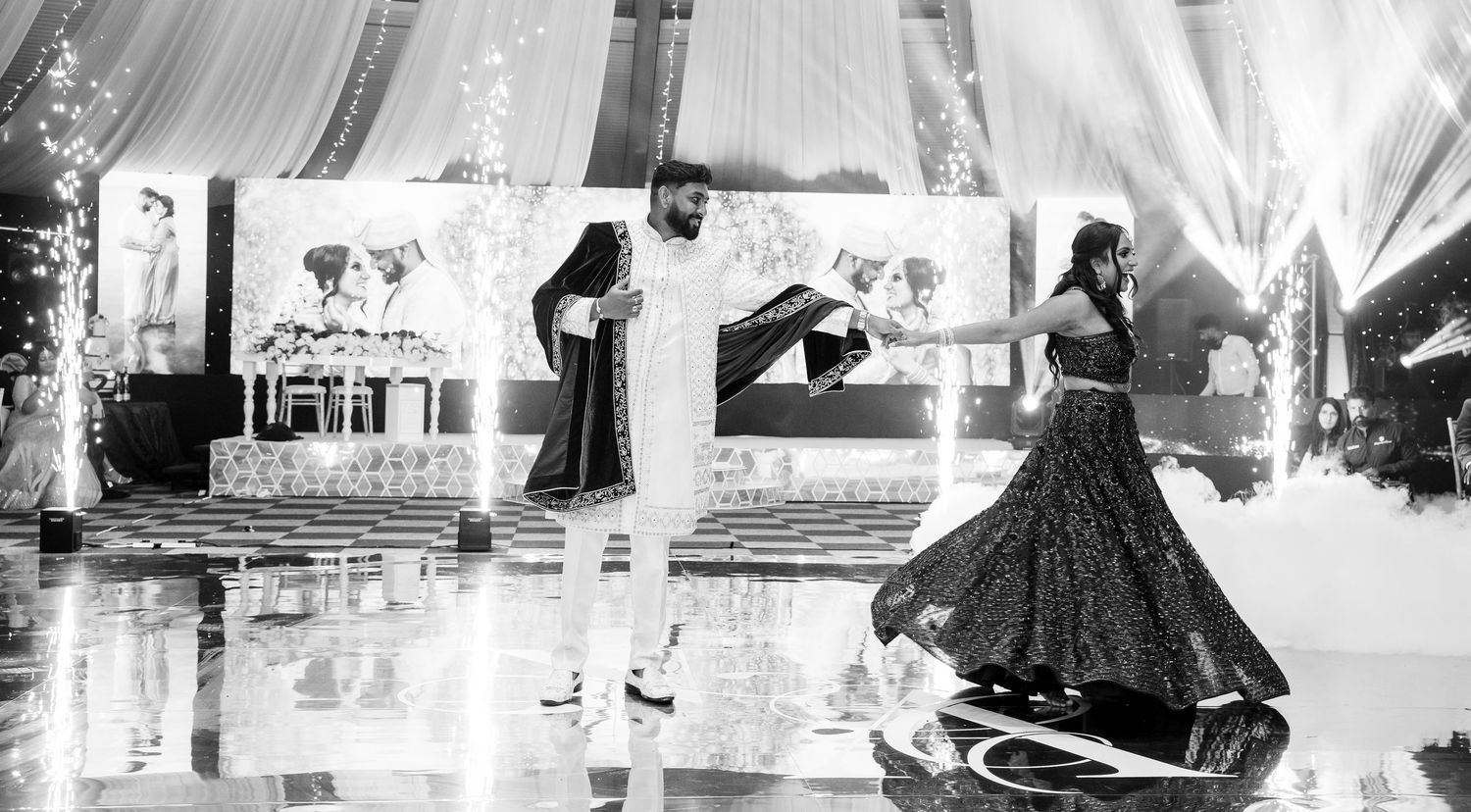 Couple dancing at an elegant Indian wedding reception in black and white photography.