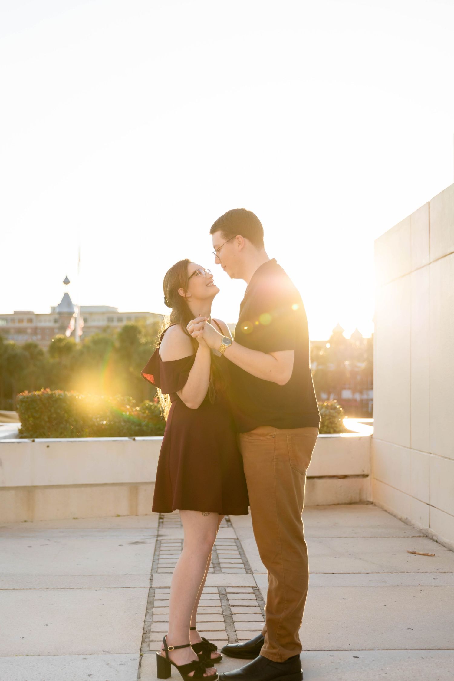 Couple dancing romantically on a rooftop terrace bathed in warm golden sunset light at Curtis Hixon Park.