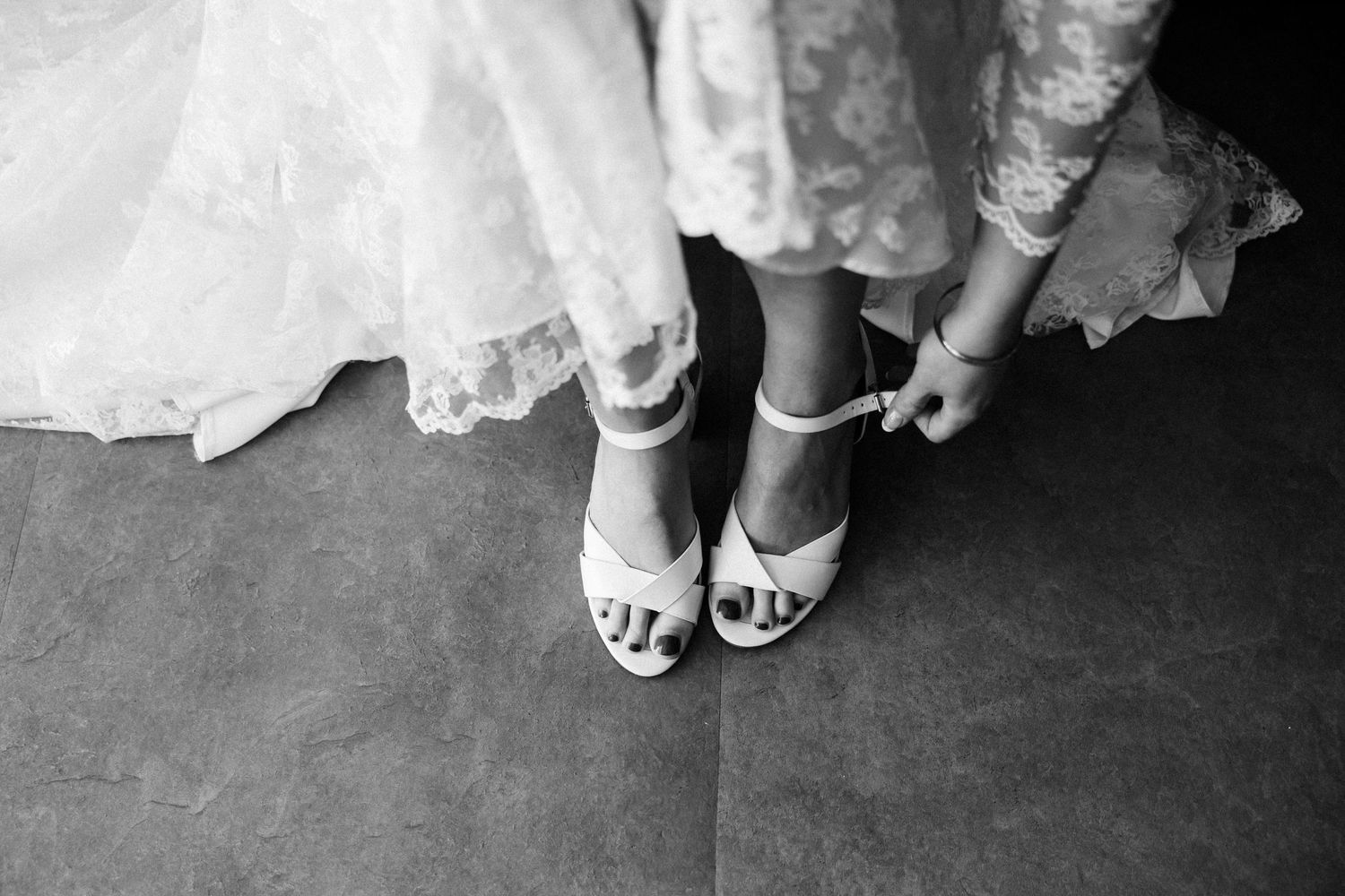 Black and white detail shot of bride's shoes being fastened on wedding morning — Oh Joy! Photography Tauranga