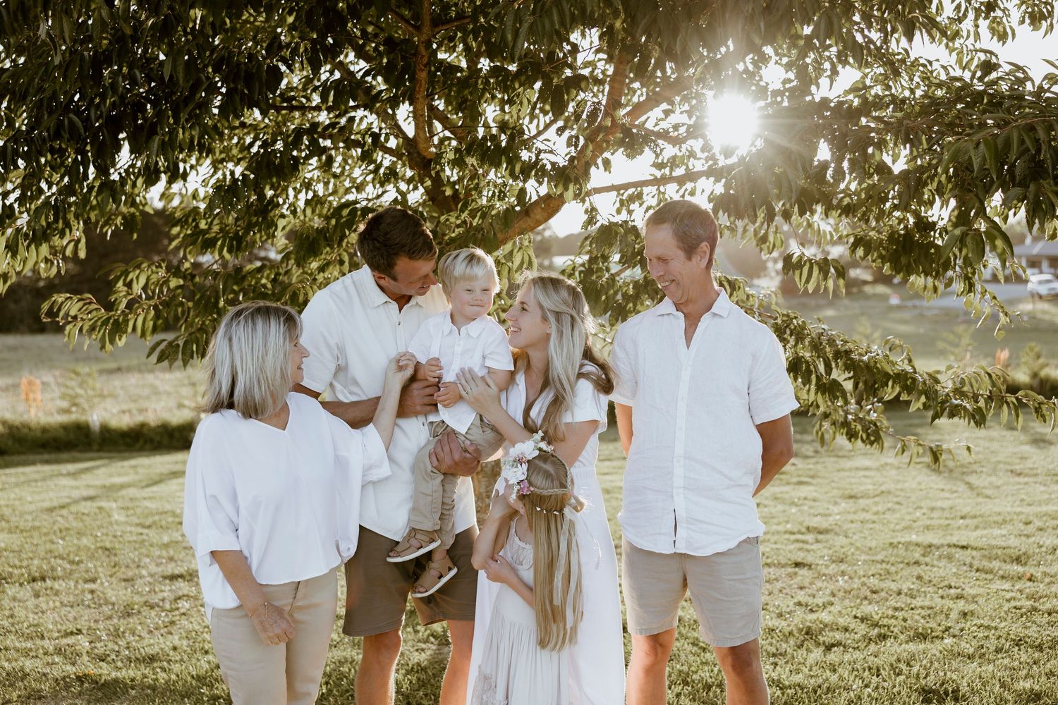 Relaxed family portrait in matching neutrals with a toddler and fluffy dog in golden hour light — Oh Joy! Photography Tauranga
