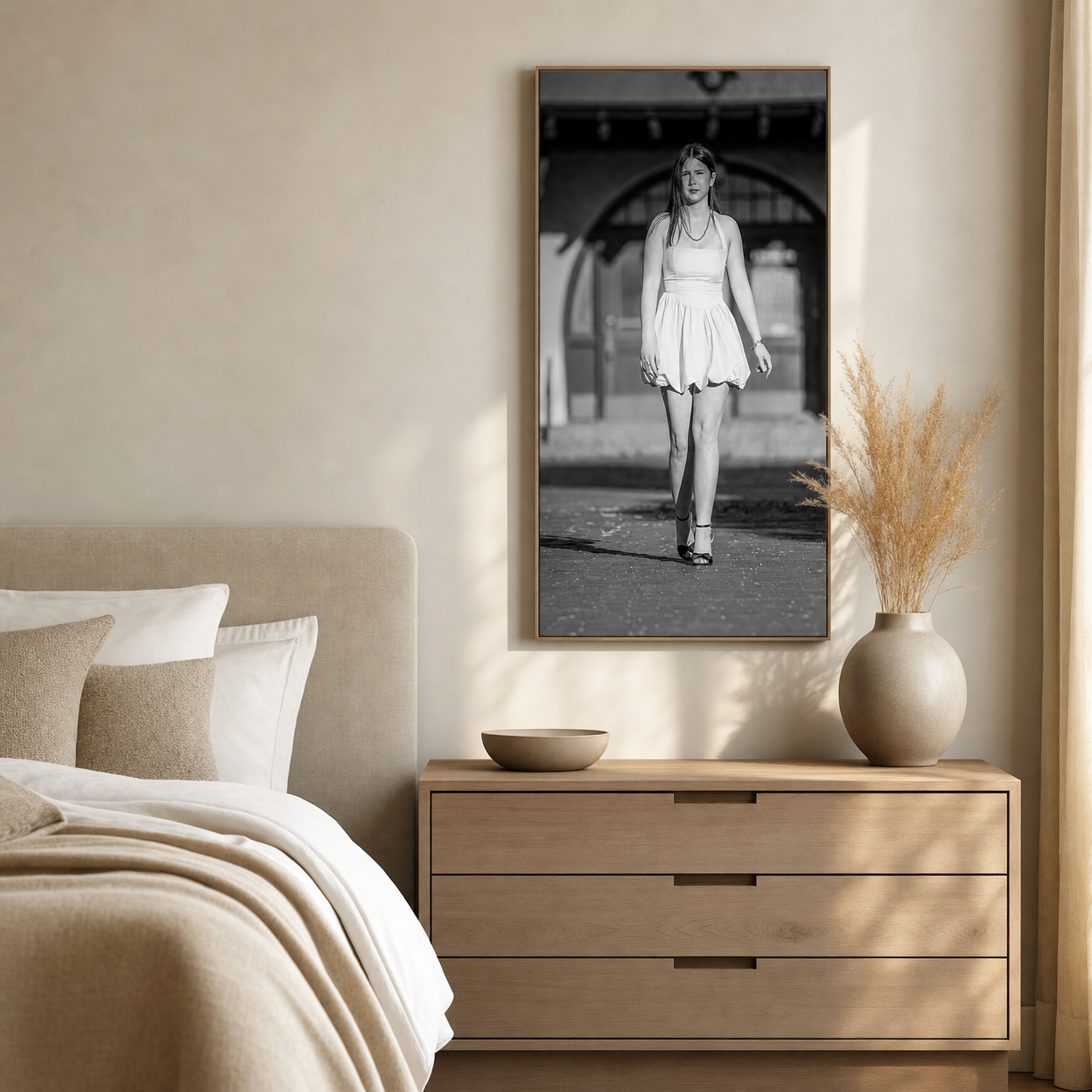 Black and white portrait of a woman in white dress in a natural wood frame above bedroom dresser.