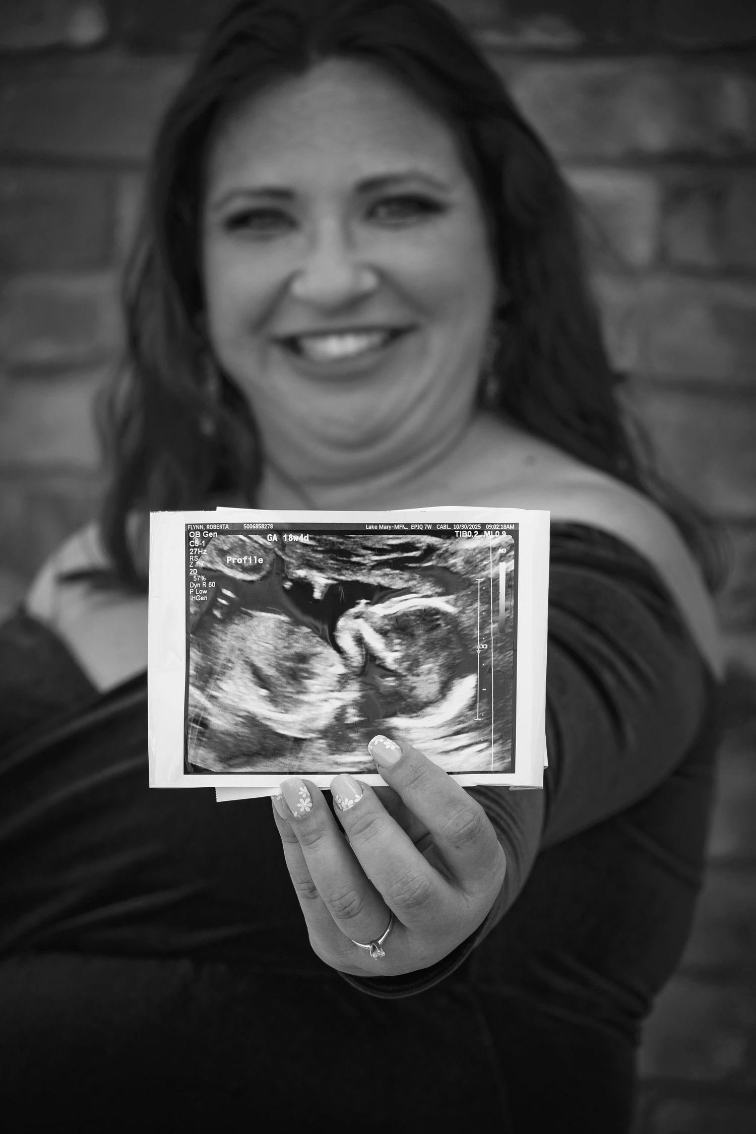 Mother-to-be holding an ultrasound photo during a maternity portrait by a maternity Photographer.