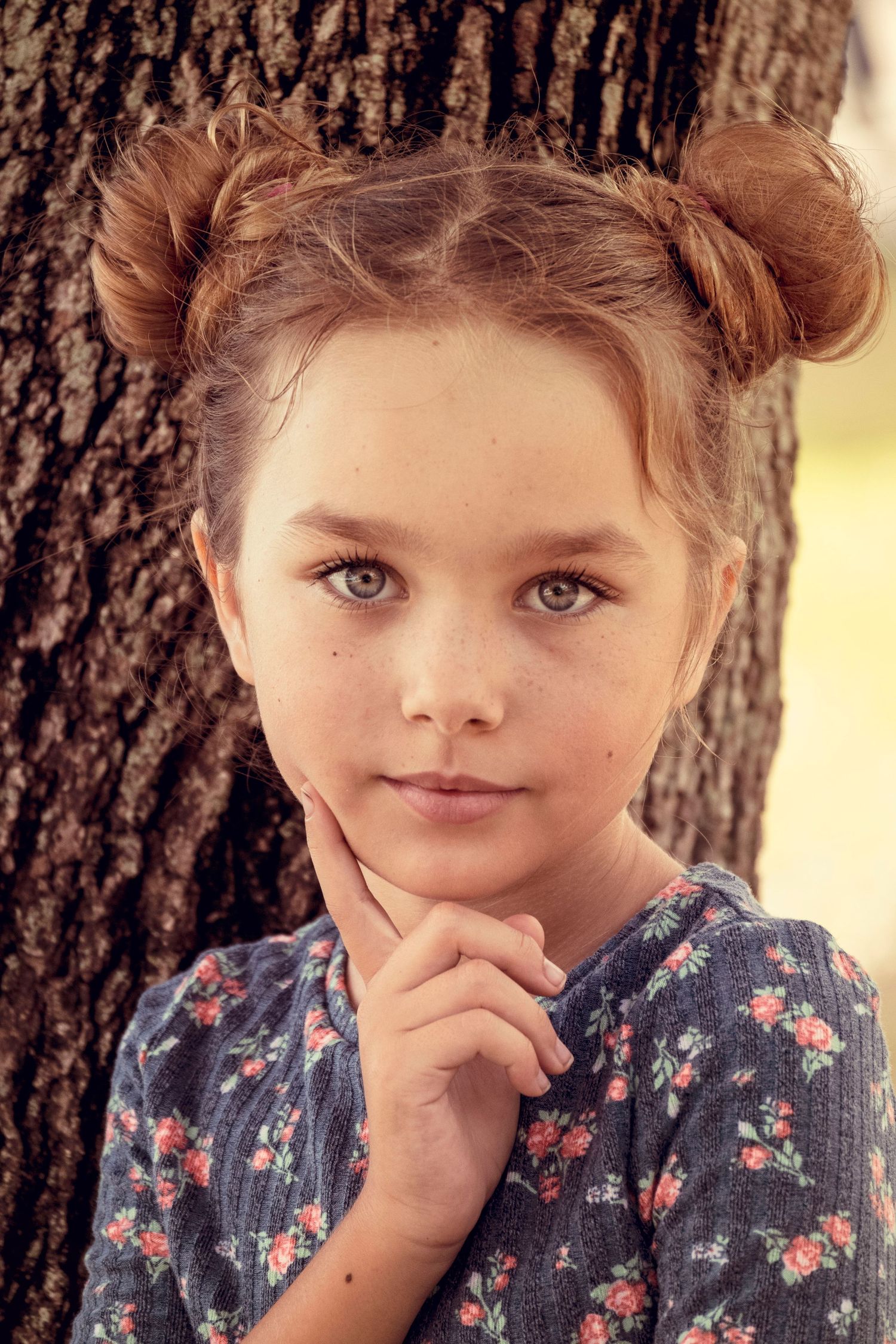 Young girl posing beside a tree during an outdoor portrait session by a Central Florida Photographer.