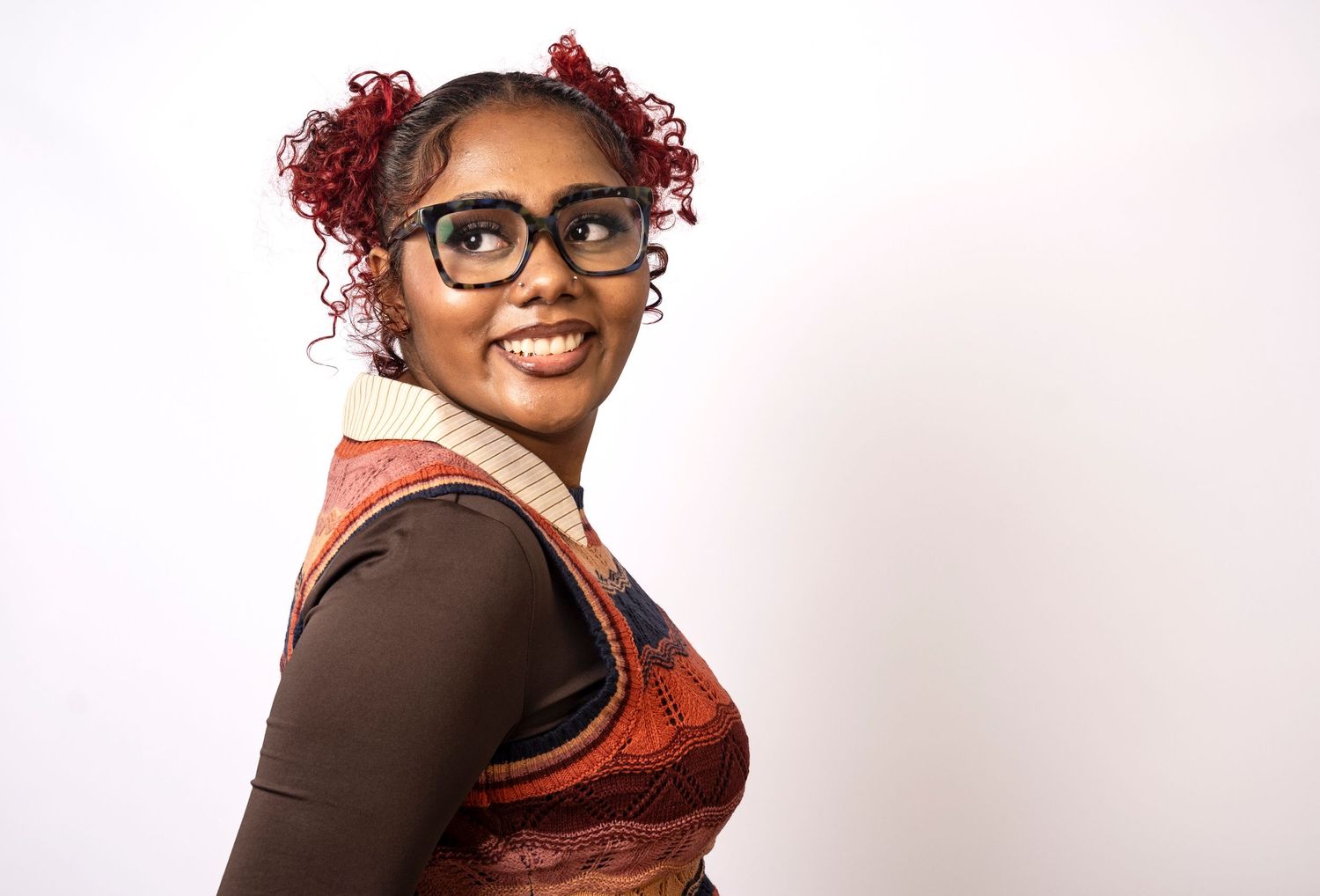 Smiling woman with colorful hair and glasses during a studio portrait by a Central Florida Photographer.