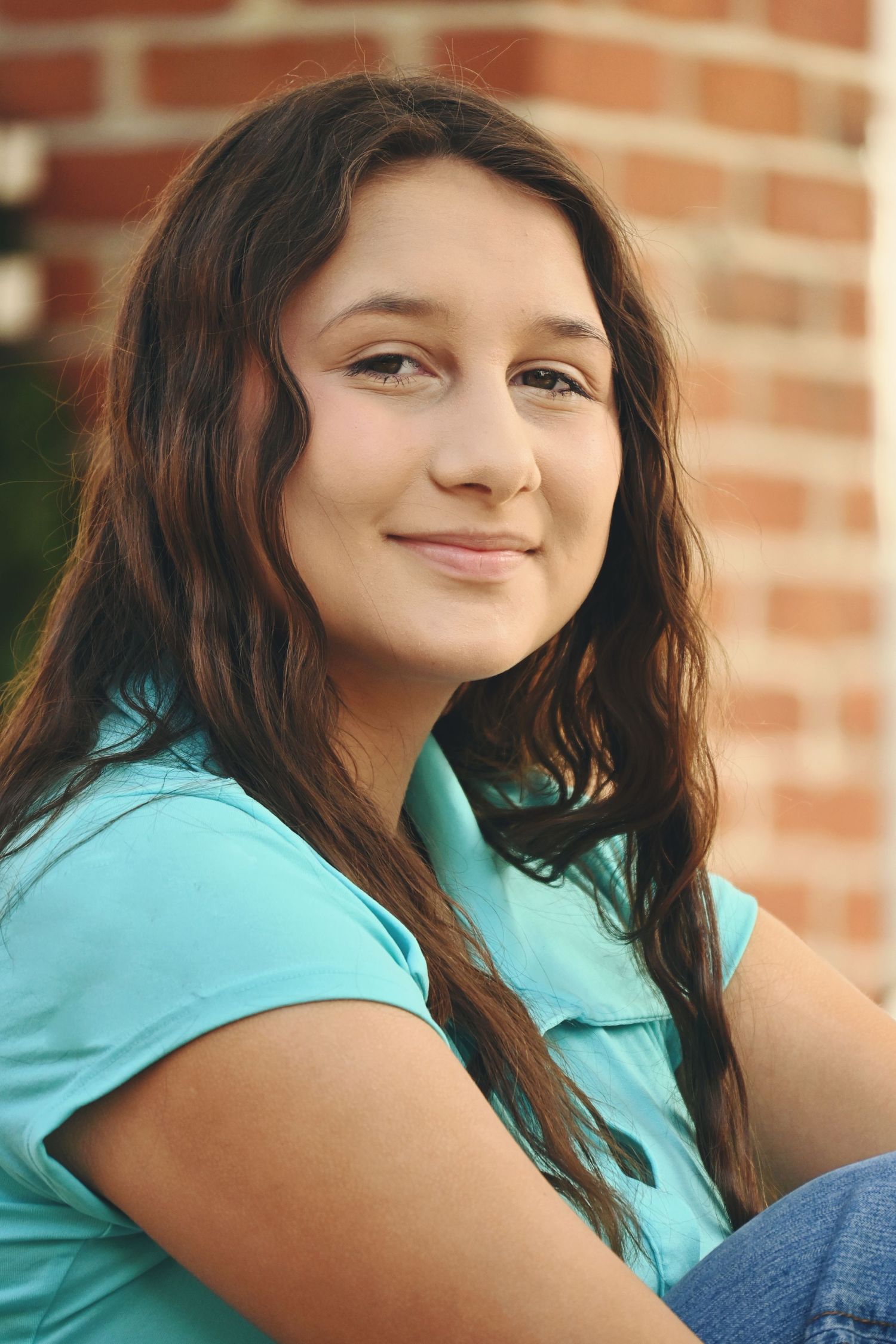 Smiling high school senior posing outdoors during a natural light session by a Central Florida Photographer.