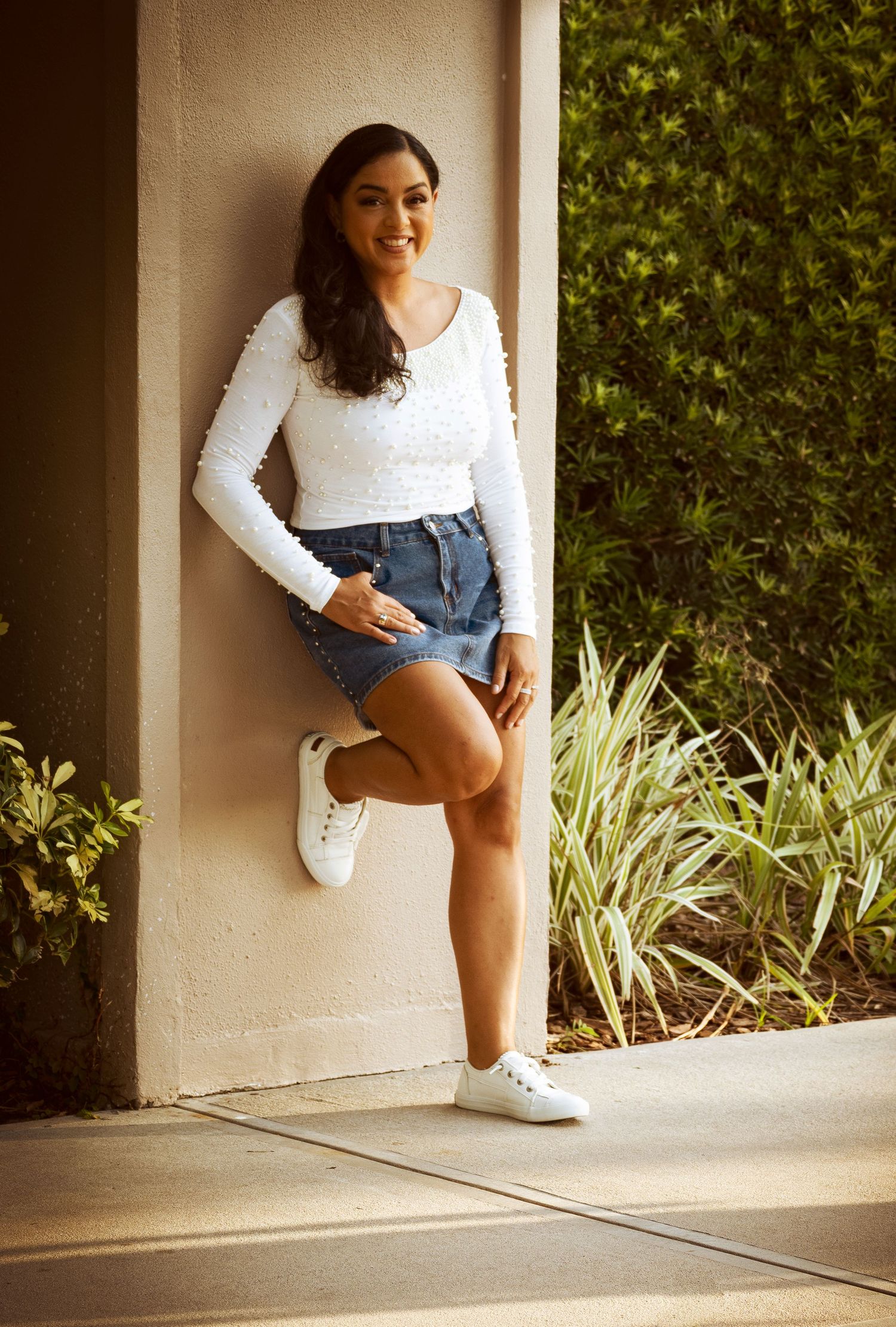 Senior girl posing beside a sunlit archway during an outdoor portrait session by a Central Florida Photographer.