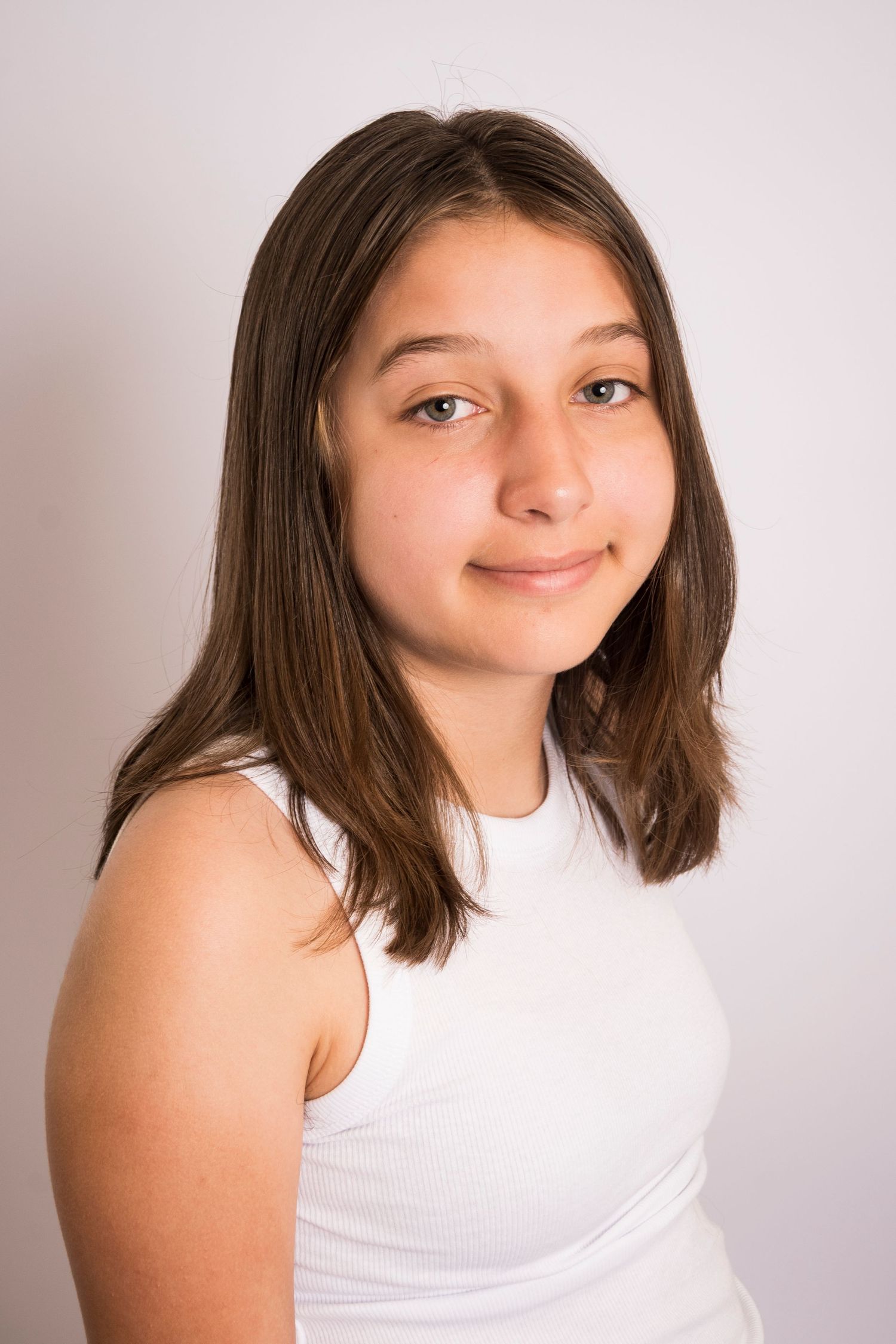 Young girl smiling during a studio portrait session by a Central Florida Photographer.