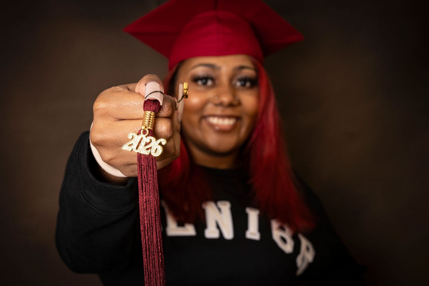 Graduate holding a 2026 charm during a graduation portrait session by a Central Florida Photographer.