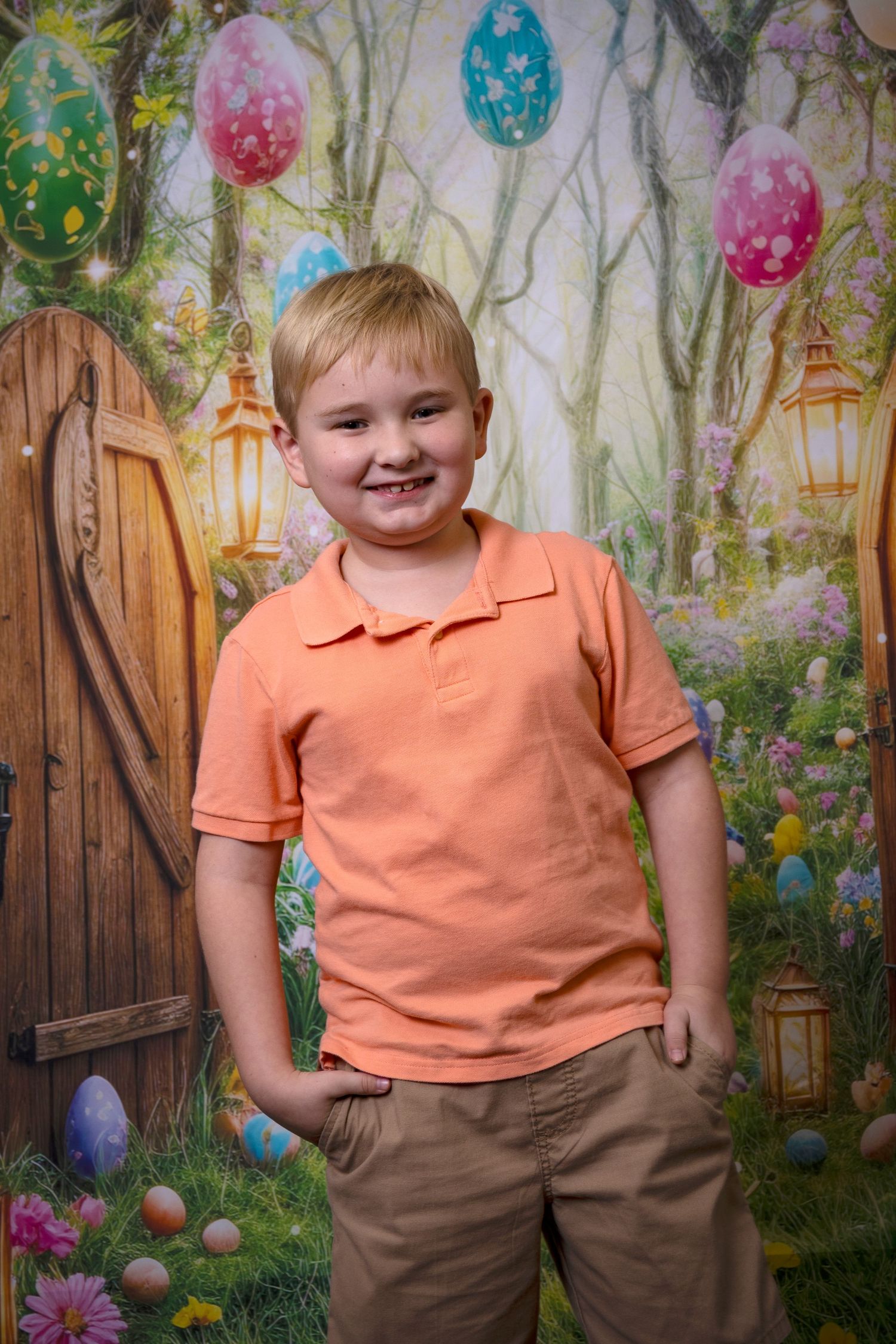 Young boy smiling among colorful Easter balloons and spring decor during a portrait session by a Central Florida Photographer.