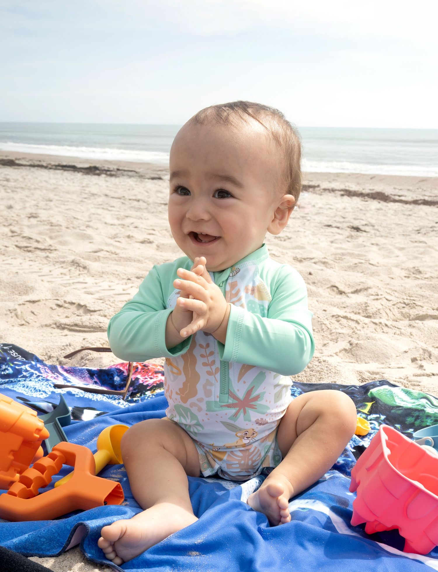 Happy baby sitting on the sand during a beach milestone portrait by a Central Florida Photographer.