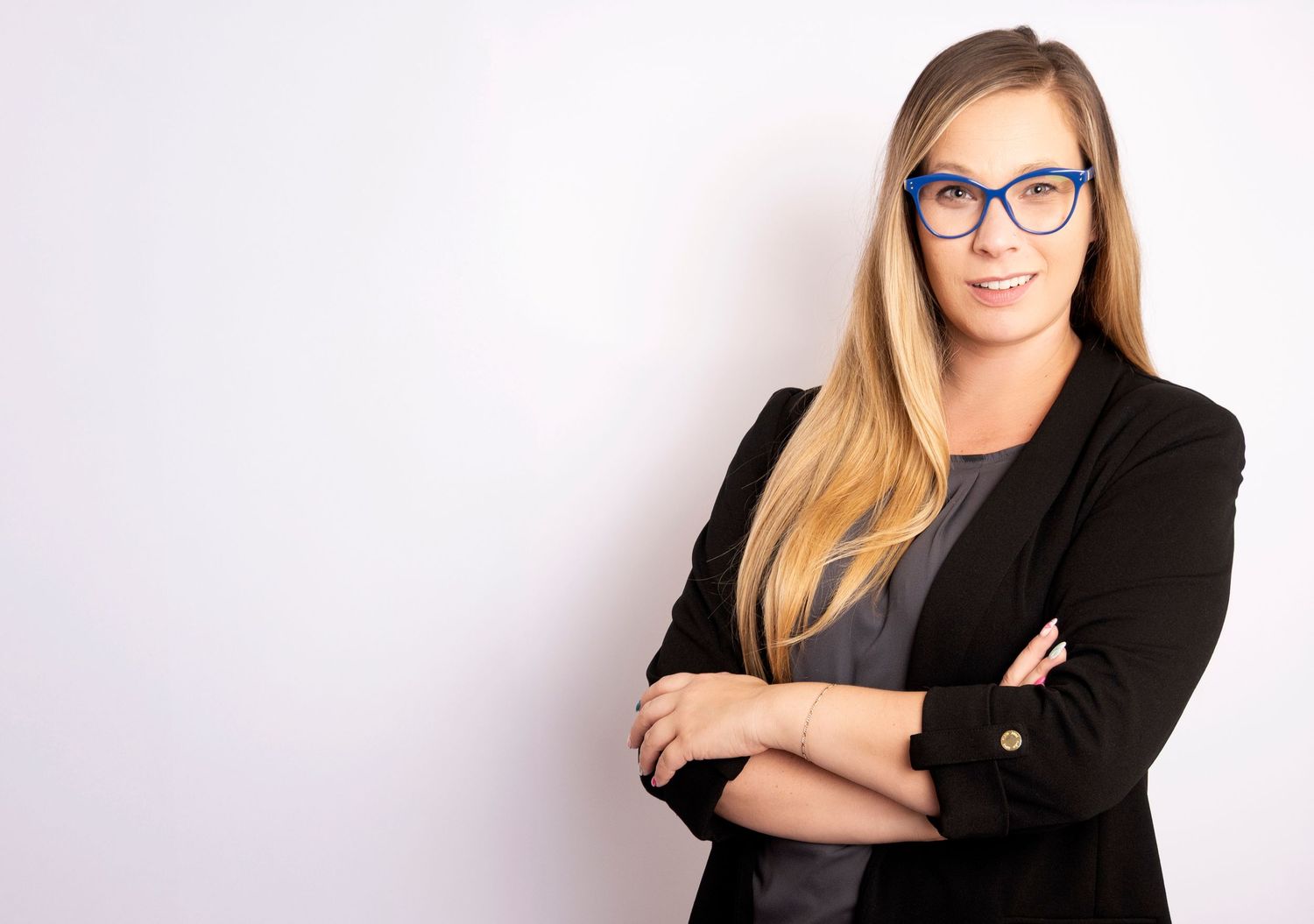 Professional woman wearing glasses and a black blazer during a business headshot session by a Central Florida Photographer.
