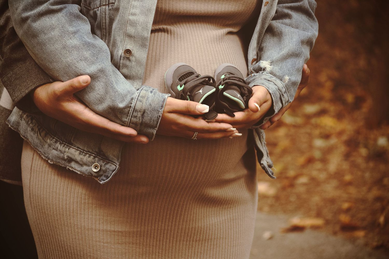 Parents holding shoes photos during a maternity announcement session by a Central Florida Photographer.