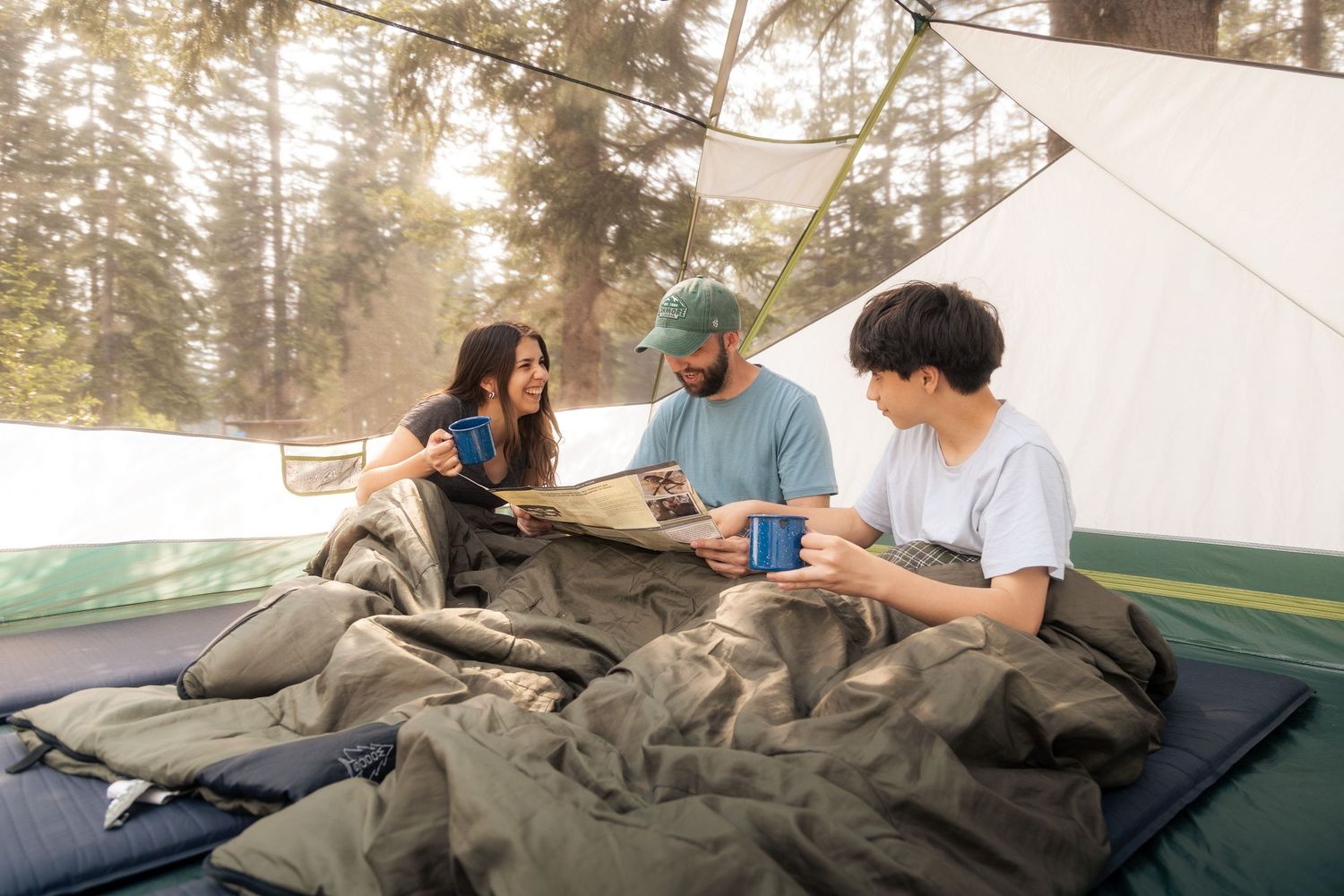 Une famille dans une tente au soleil à lire une carte et rire dans l'Ouest Canadien — Jonathan Ouimet Photographie