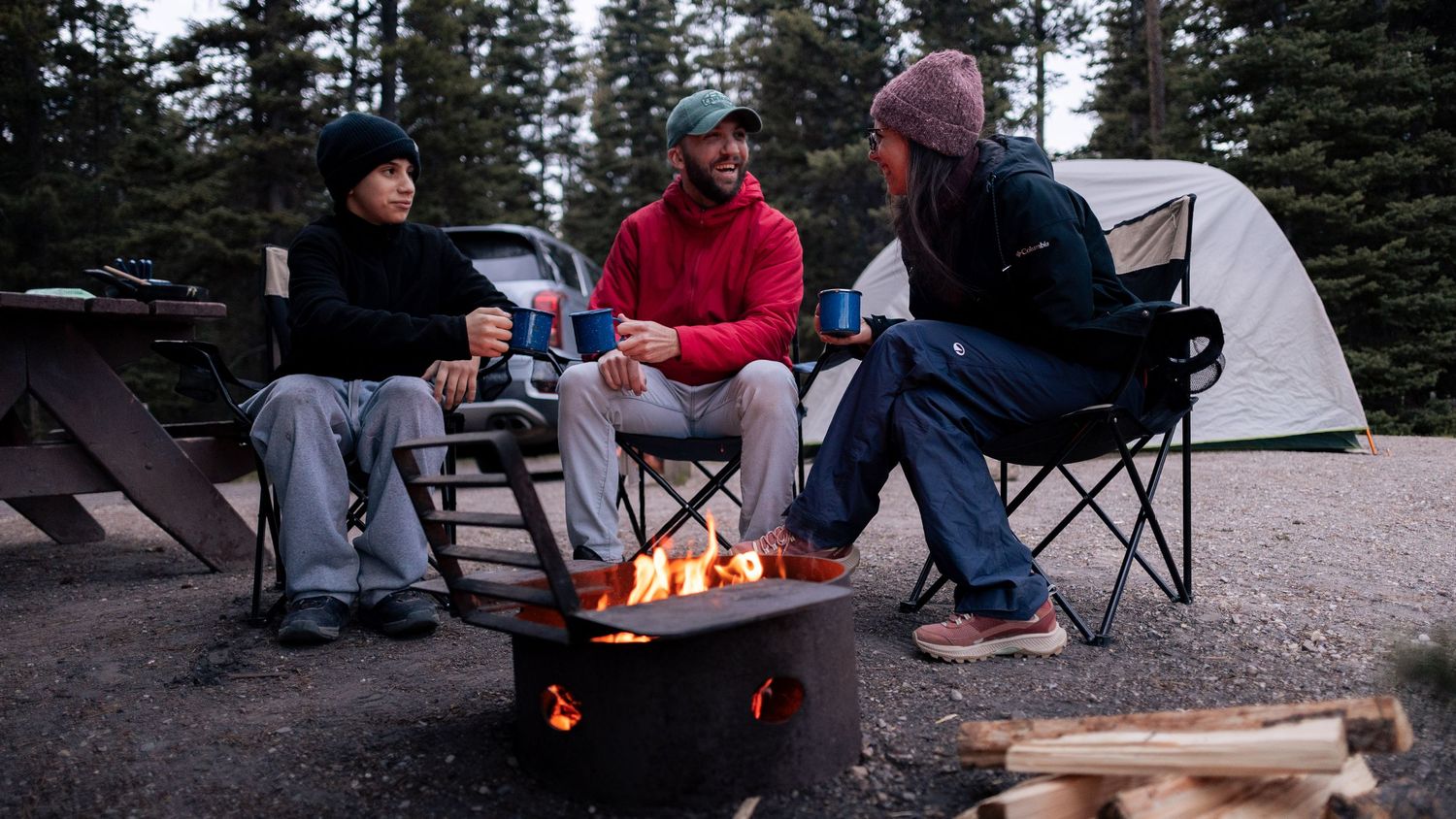Une famille qui rit autour d'un feu en début de soirée dans l'Ouest Canadien — Jonathan Ouimet Photographie