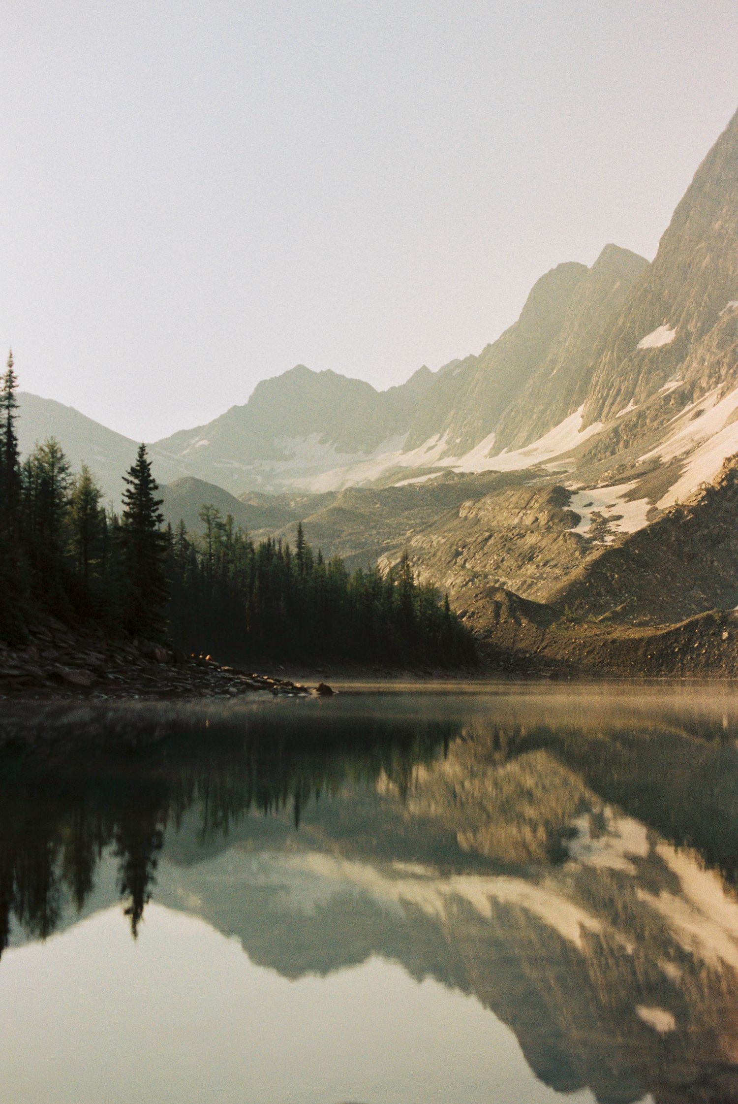 Film image of mountain landscape with reflection into lake.