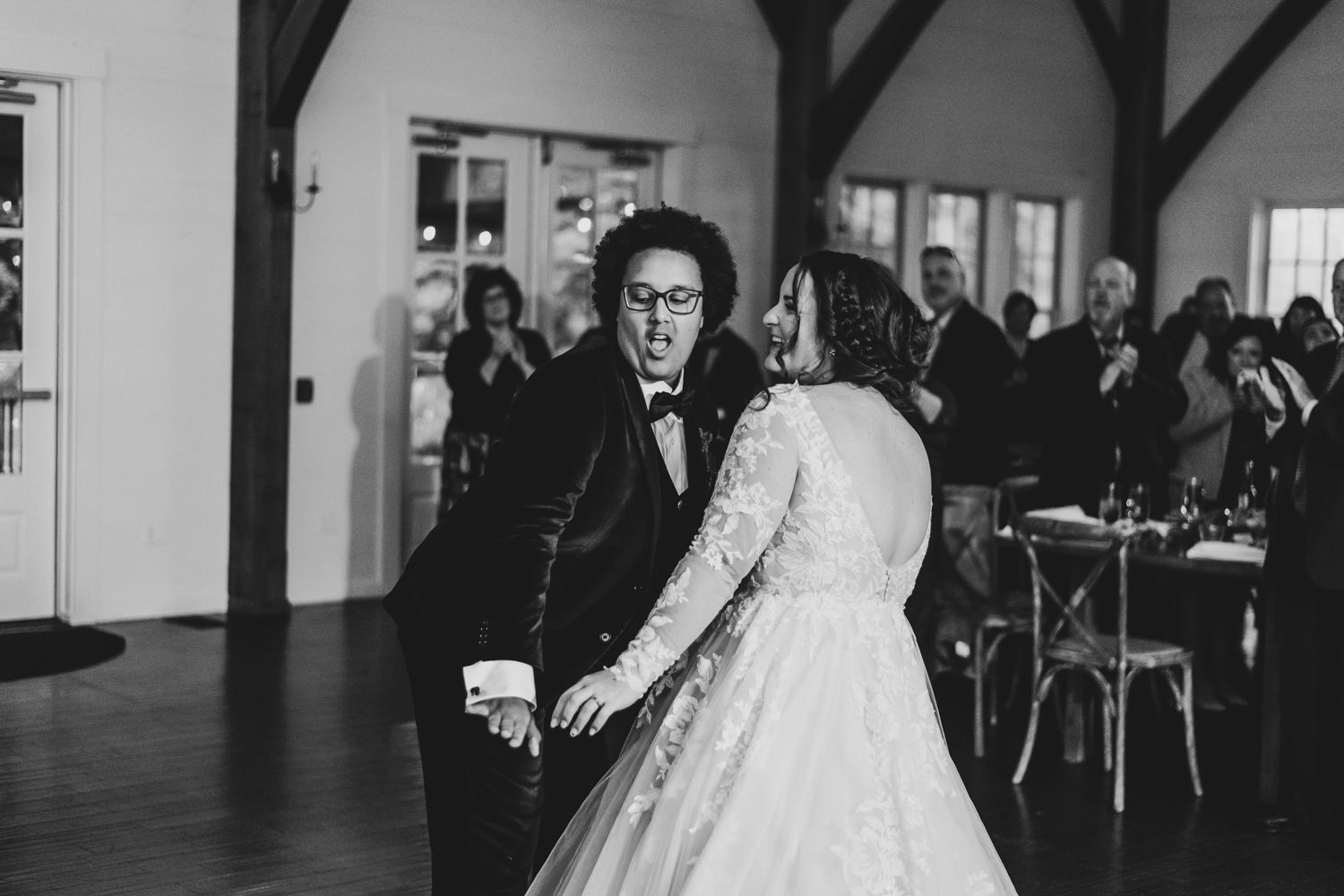 Black and white photo of bride and groom sharing first dance at wedding reception.