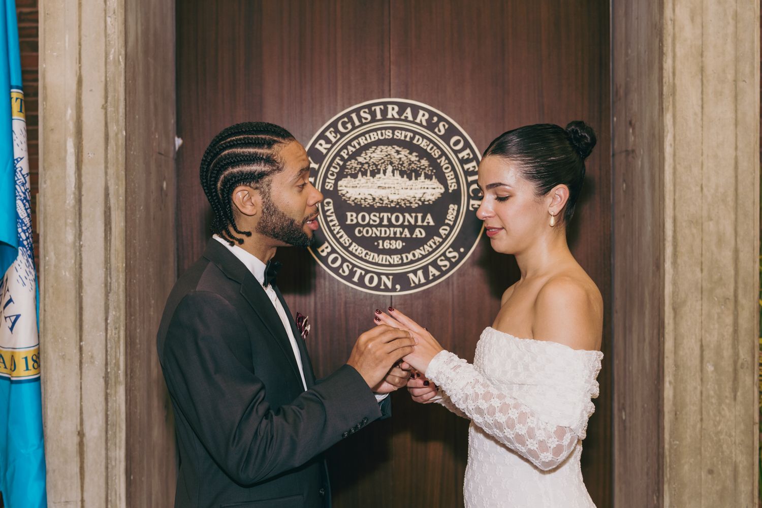 Couple exchanging rings at Boston City Hall Registrar's Office during an intimate civil wedding ceremony.