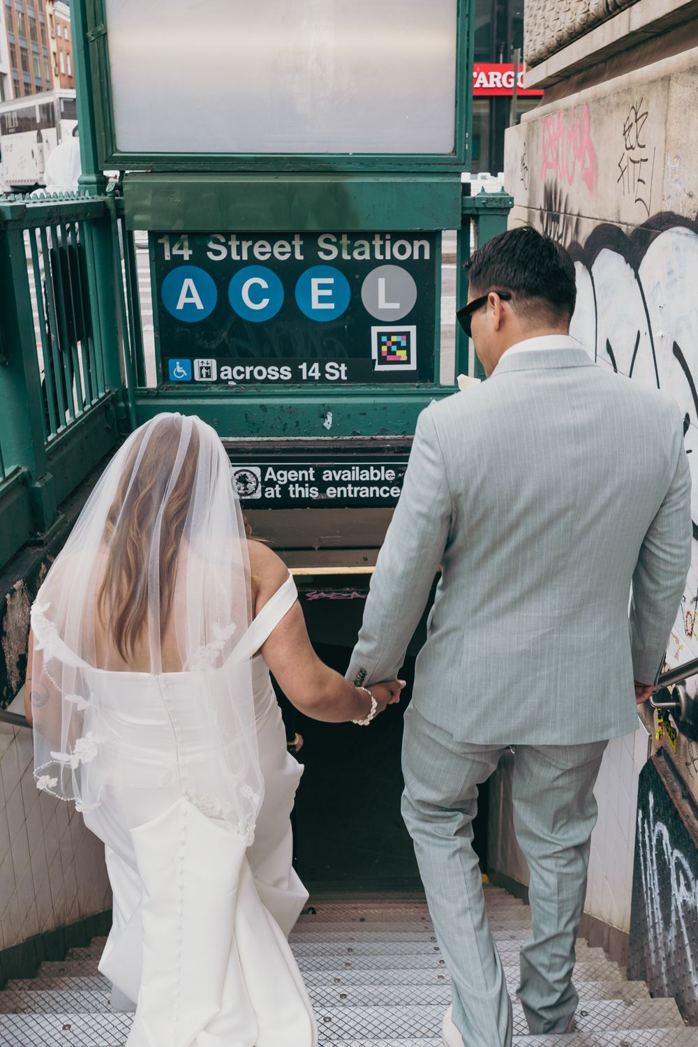 Wedding couple holding hands entering NYC 14th Street Station ACE subway.