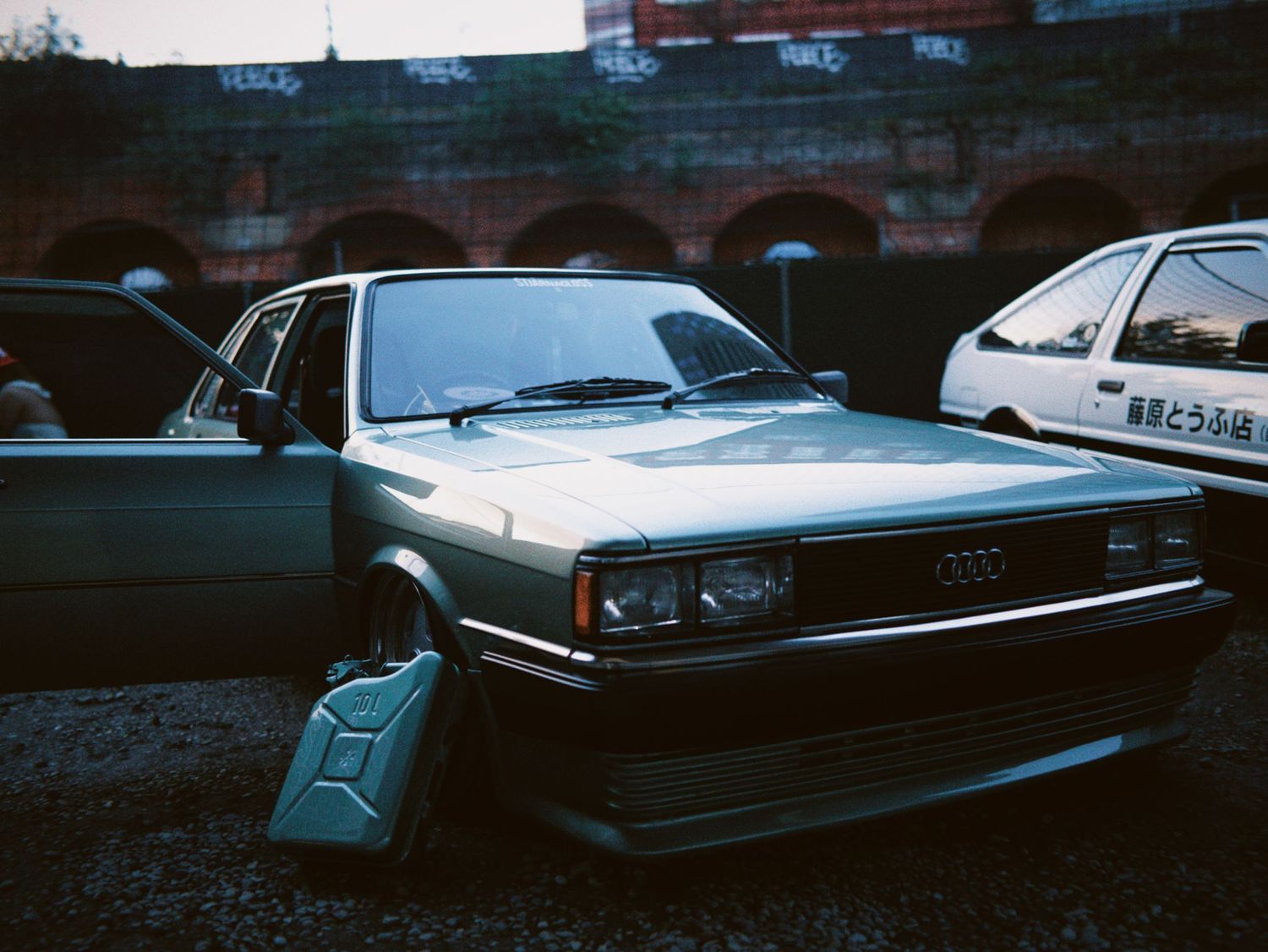 Vintage grey Audi saloon parked at an evening car meet in London.